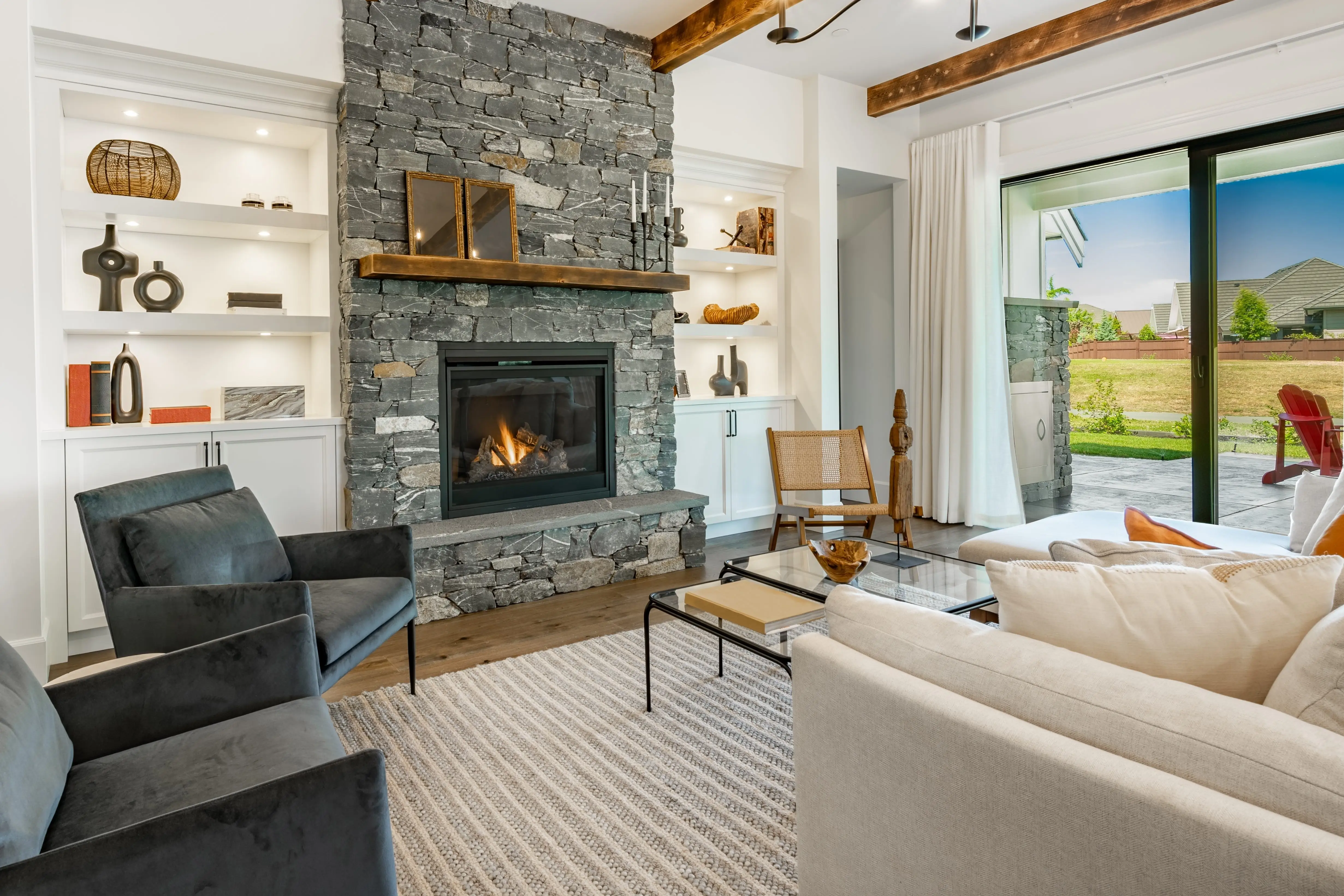 Fireplace with built-in bookshelves next to it, wood accent beams on ceiling