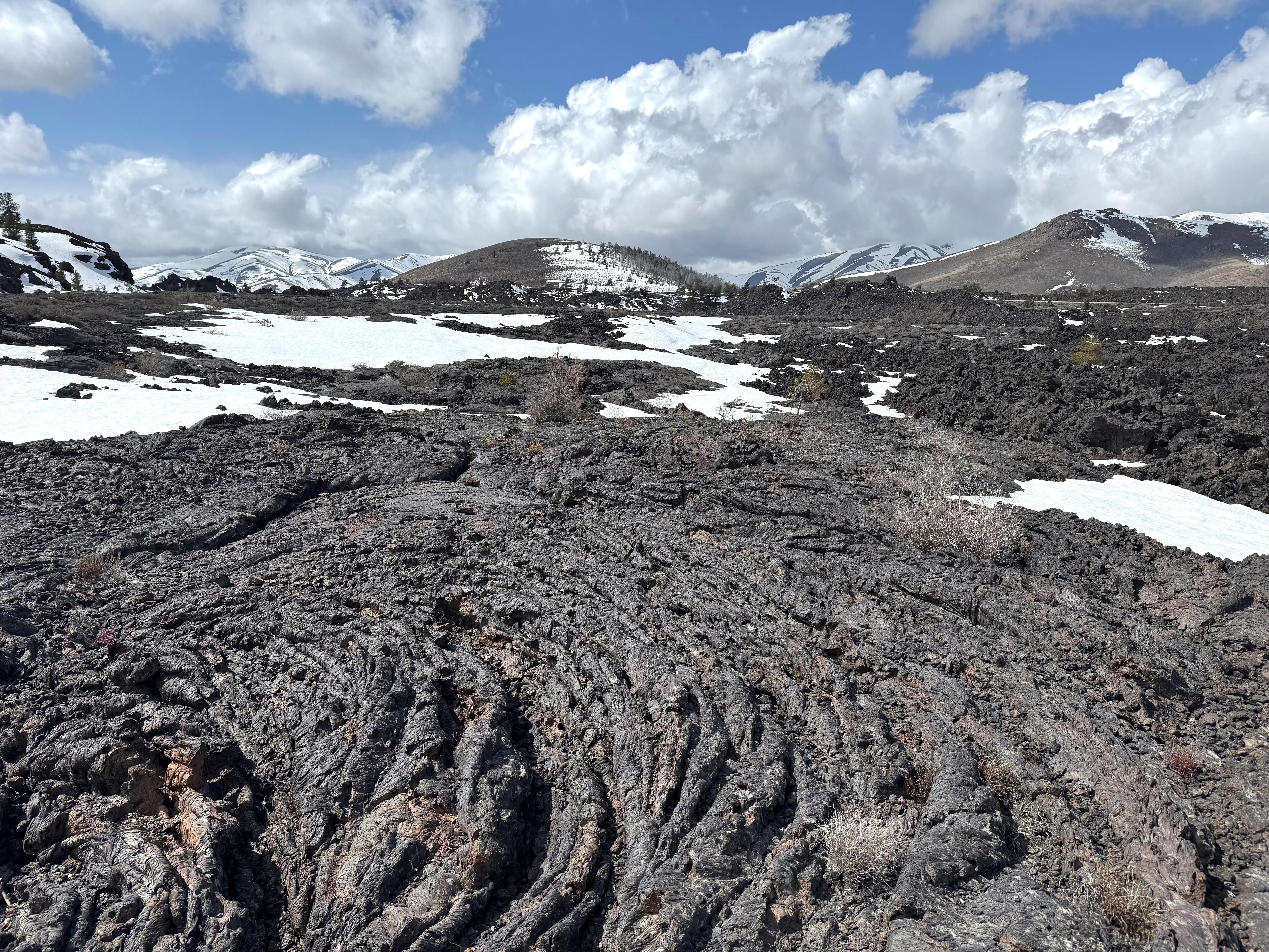 A lava field in Craters of the Moon National Monument that's partially covered in snow.