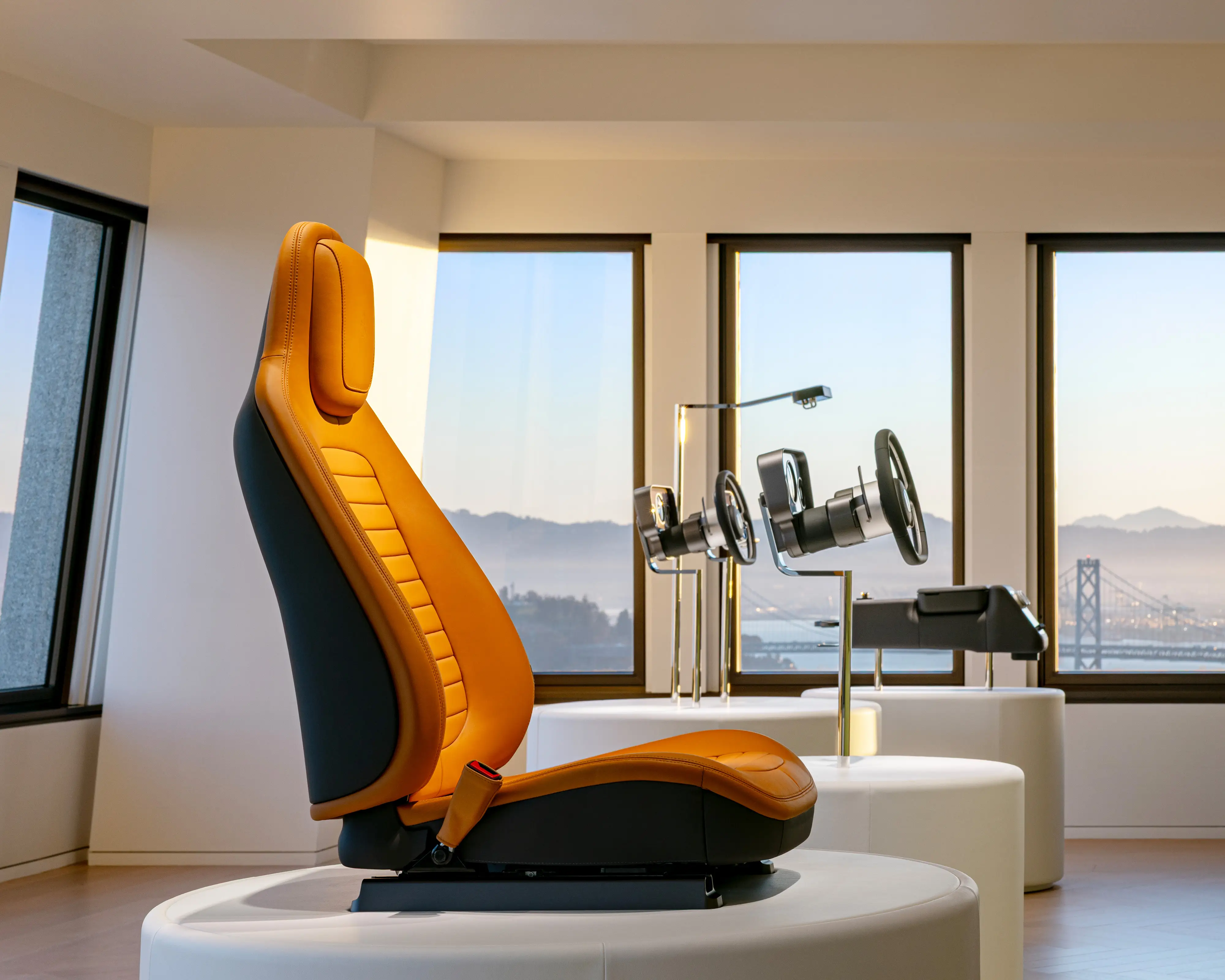 A light brown chair, steering wheel, and center console are displayed in a San Francisco showroom.
