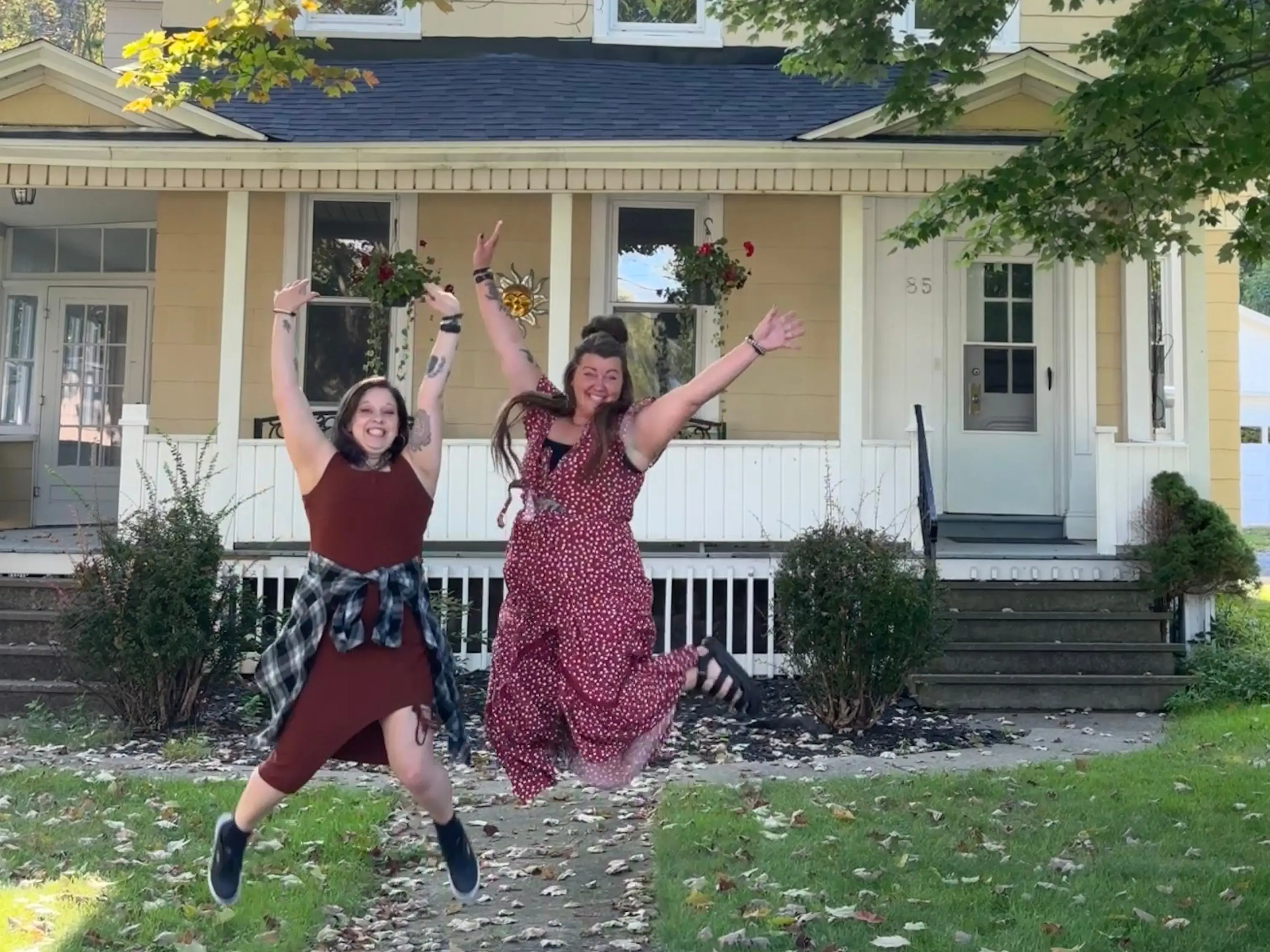 Friends jumping in front of house