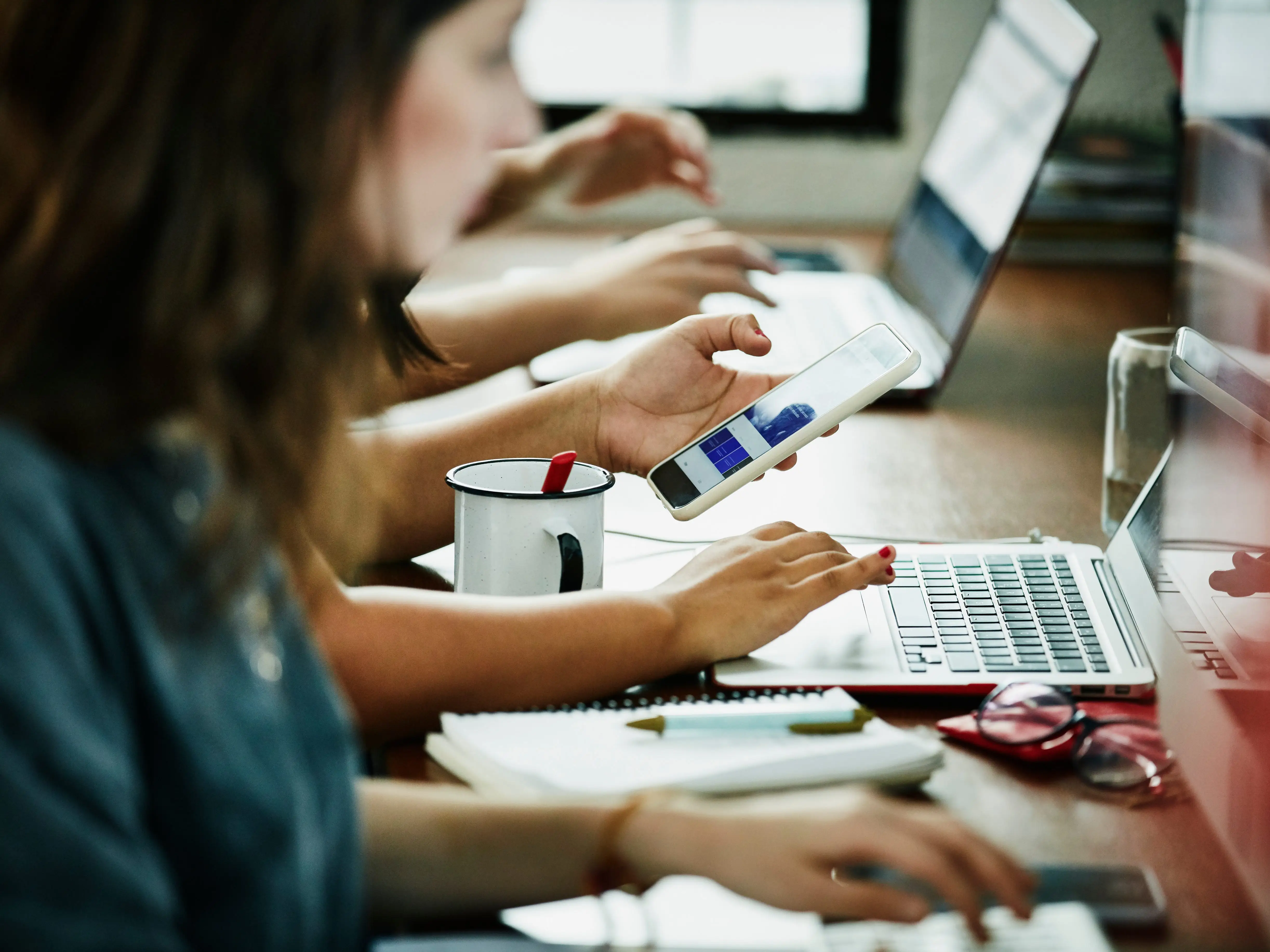 Workers sitting, one looking at phone