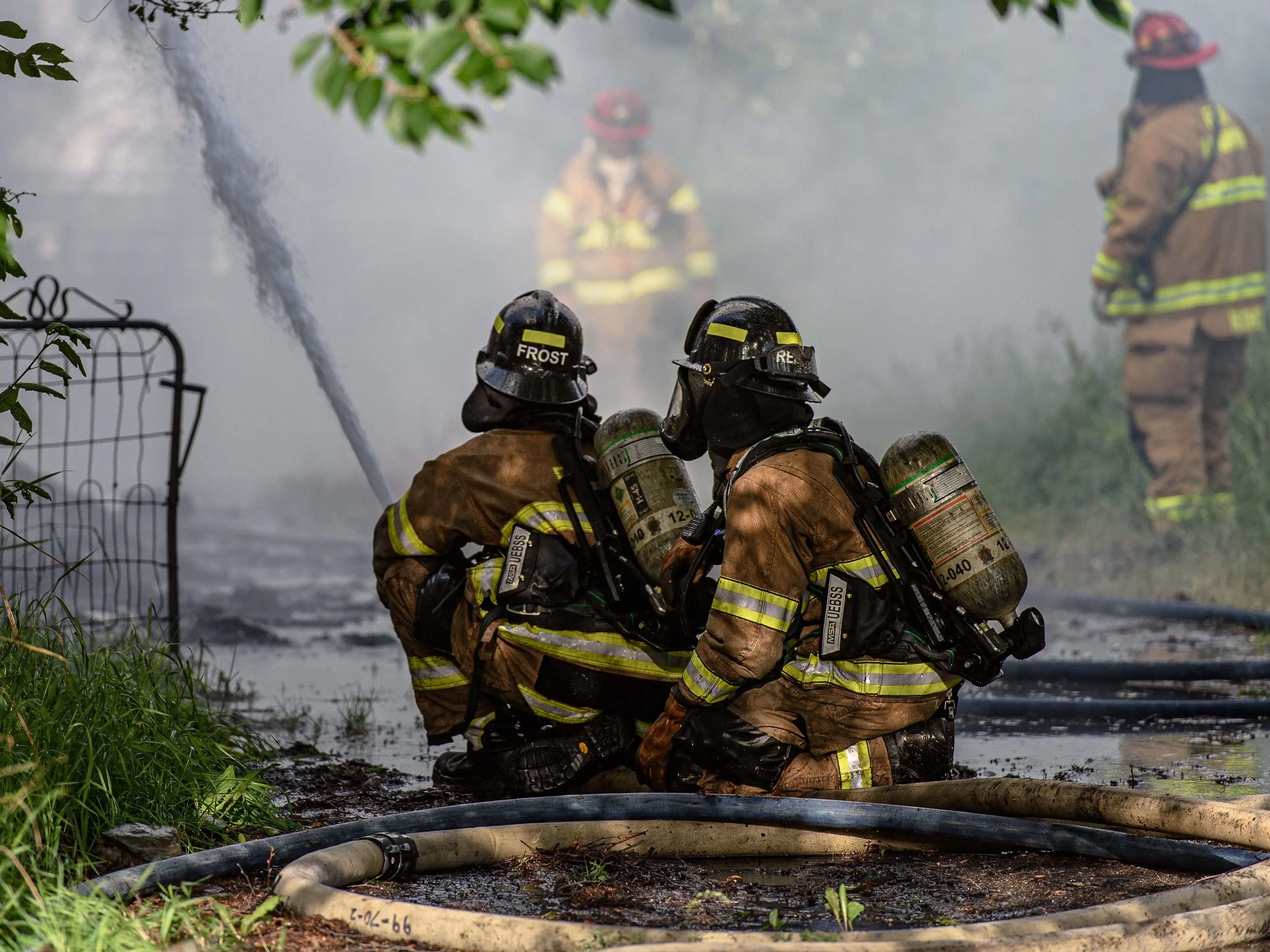Two firefighters using a hose in Fairbanks, Alaska.