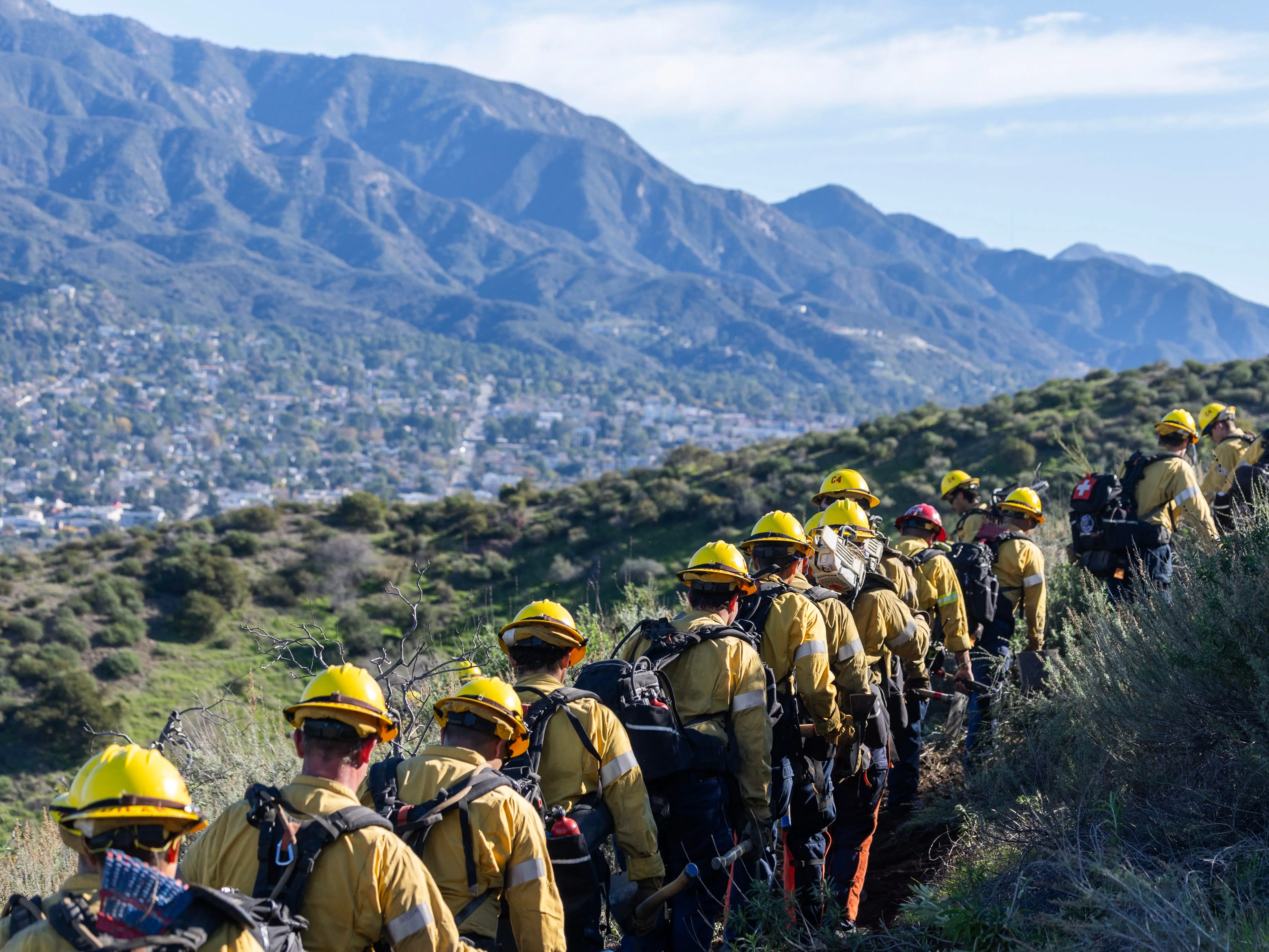 A line of wildland firefighters walking along a trail during training in Sunland, California.