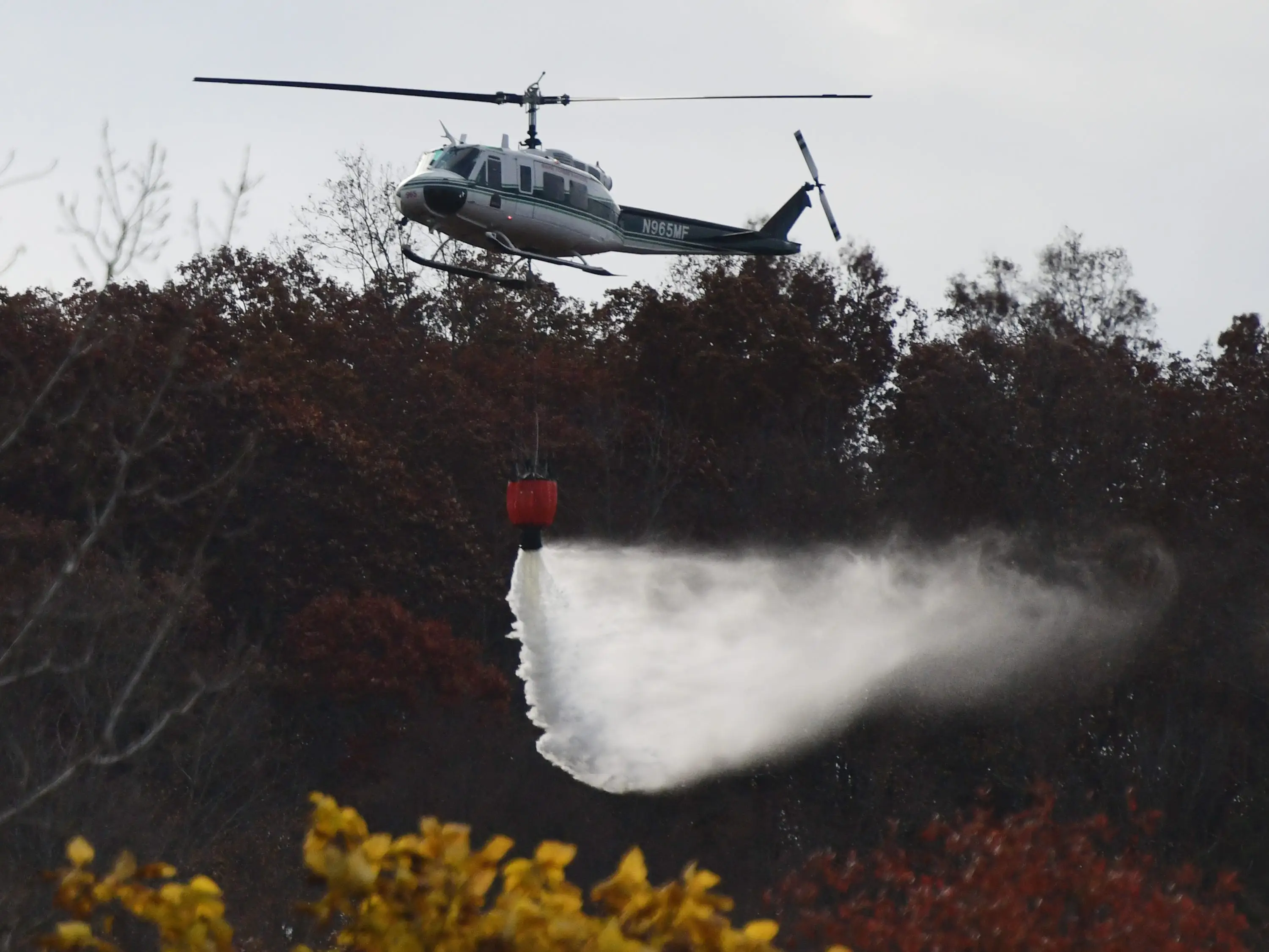 A helicopter dumping water to fight a brush fire at Lamentation Mountain in Berlin, Connecticut.