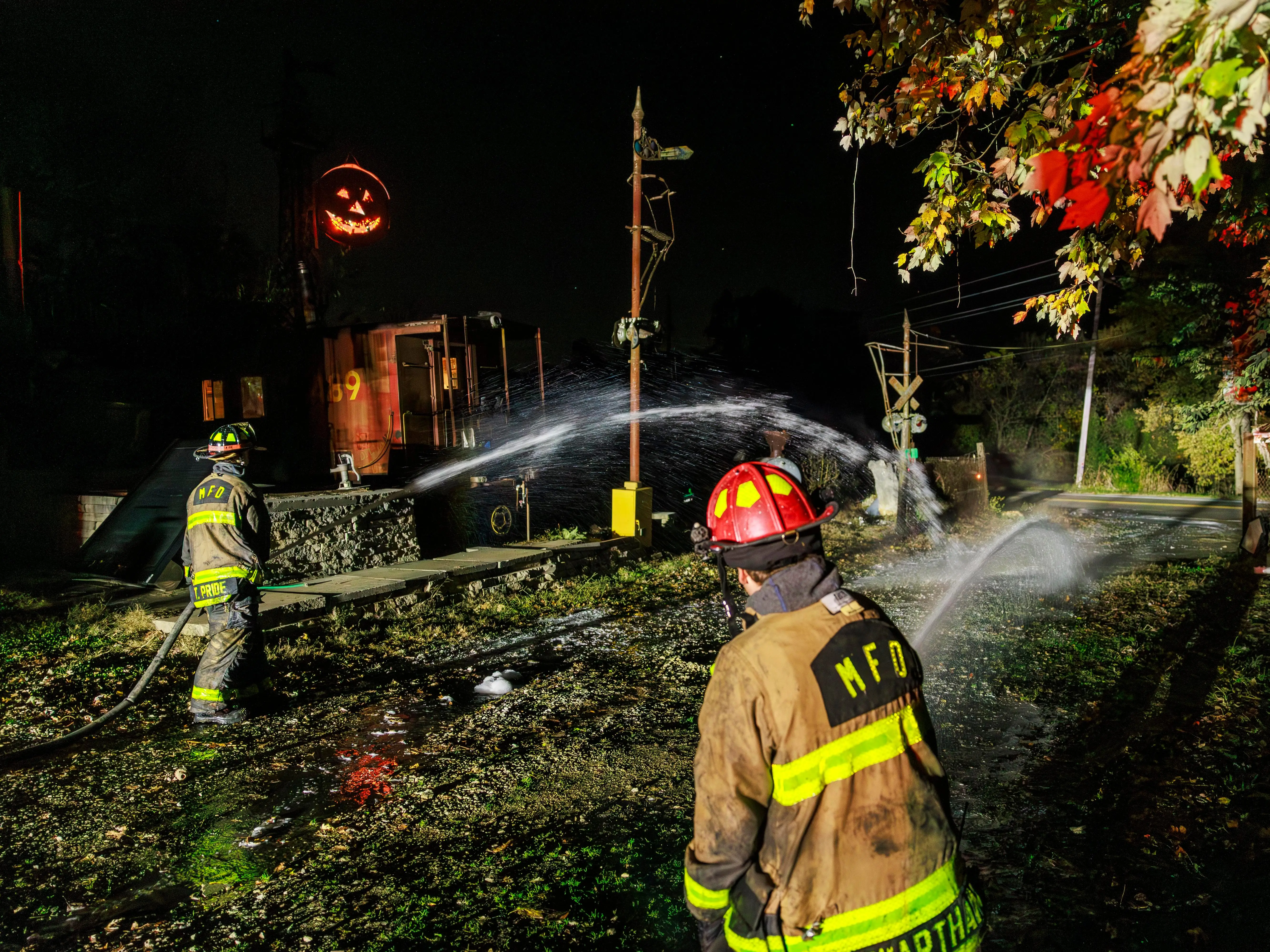 Two firefighters using hoses in the aftermath of a fire in Bloomington, Indiana.