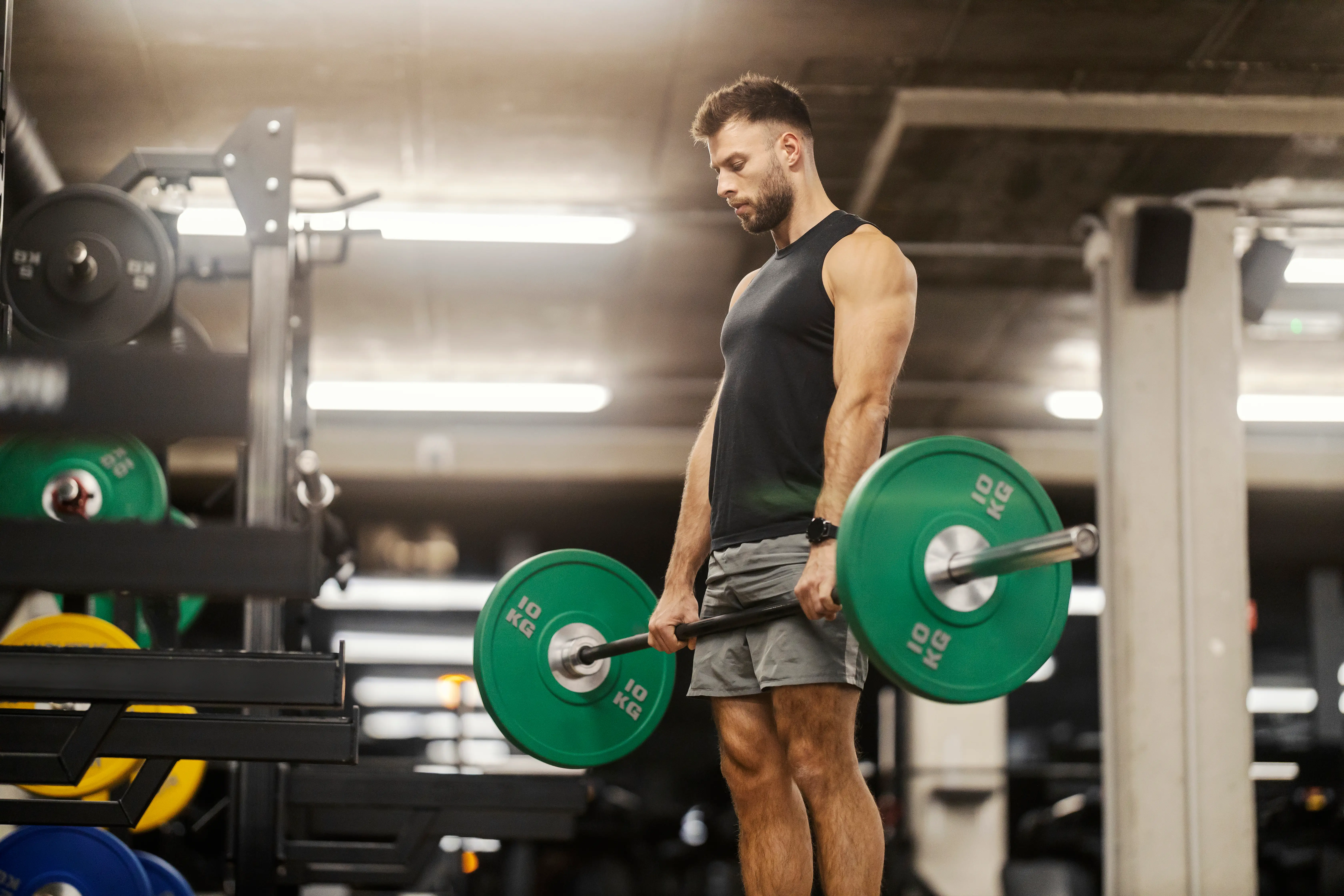 a man lifting weights with a barbell in the gym