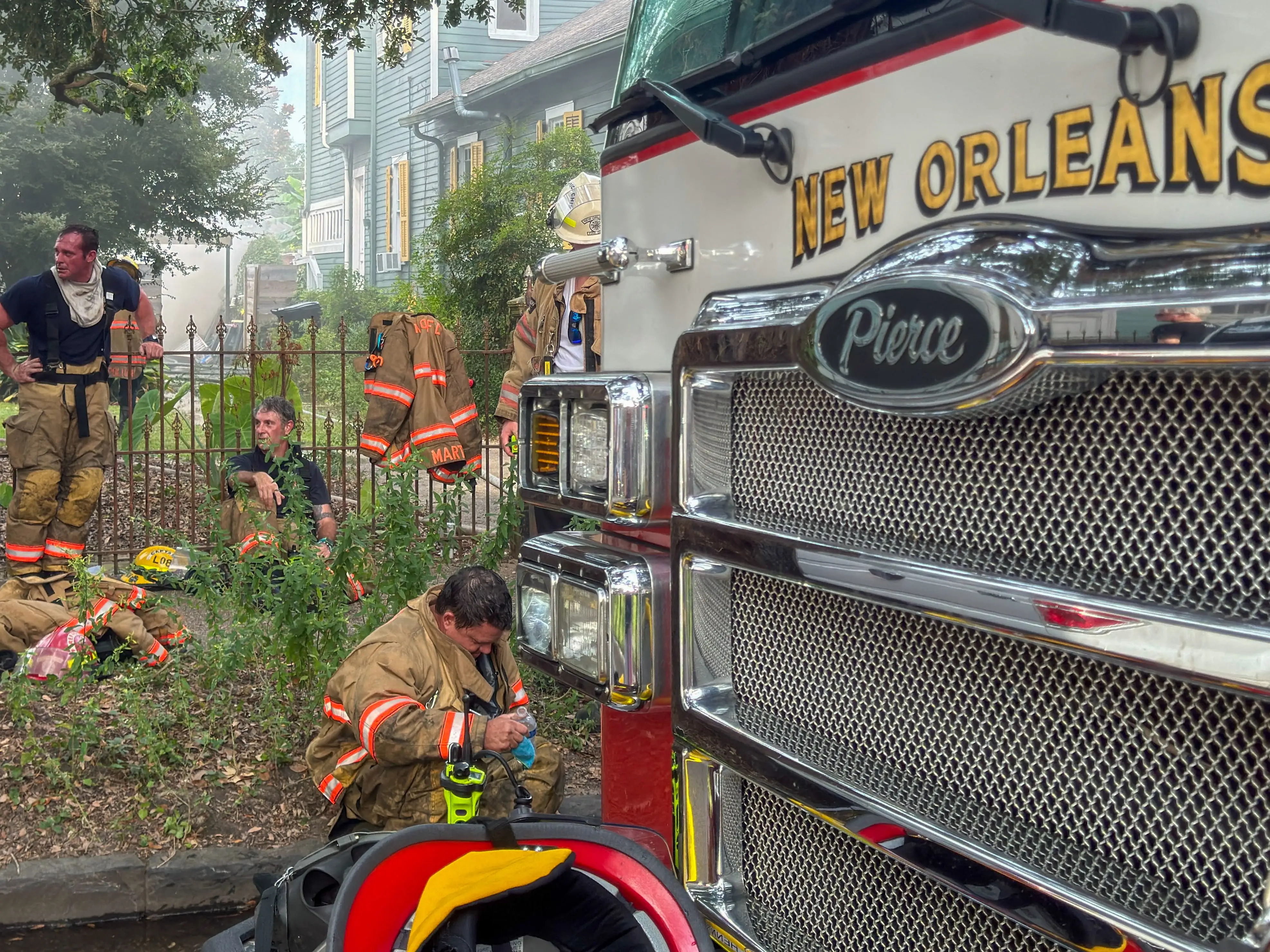 Firefighters rest next to a fire engine after extinguishing a fire in New Orleans, Louisiana.