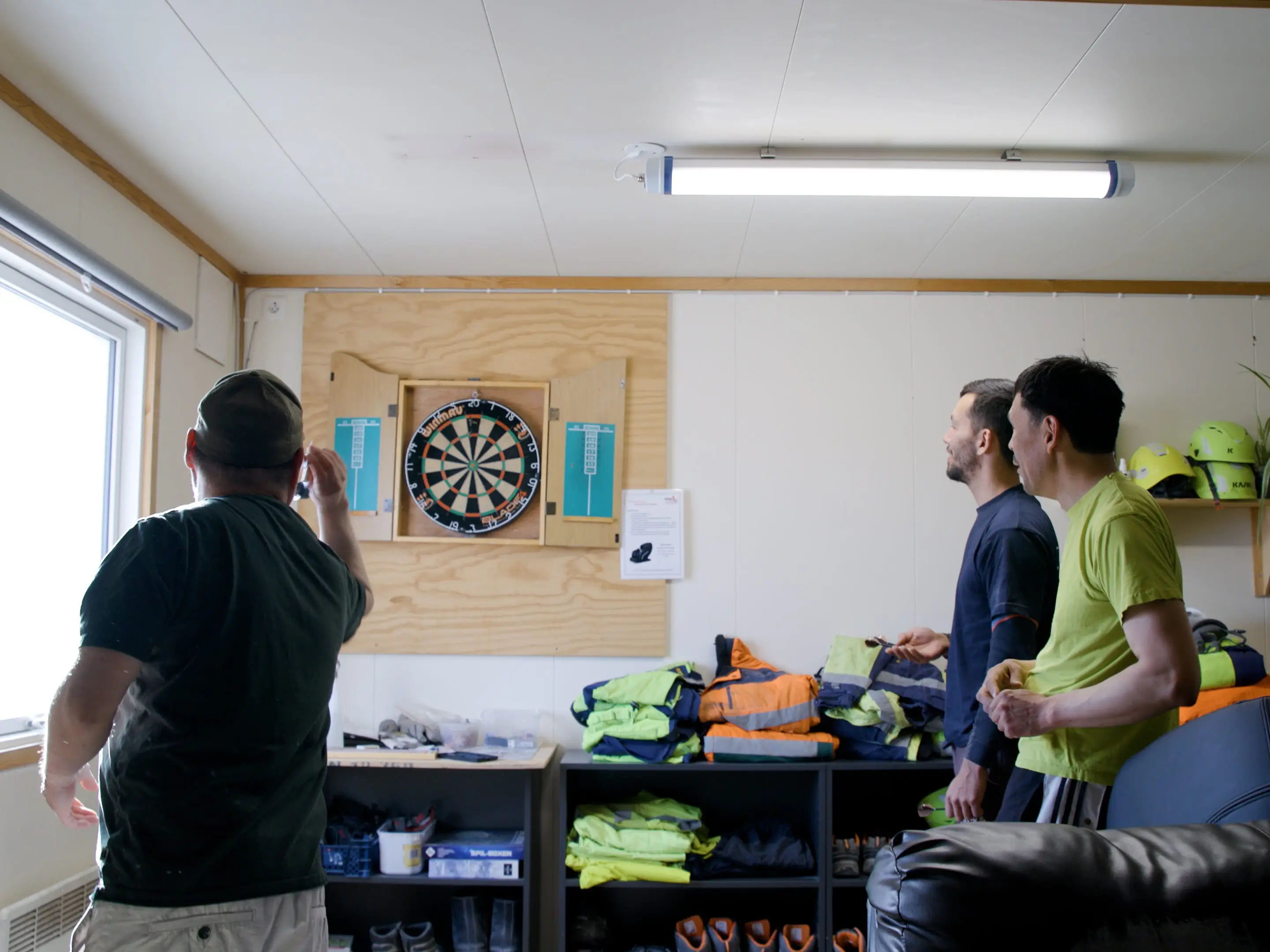 Miners at Lumina play darts in a common area.