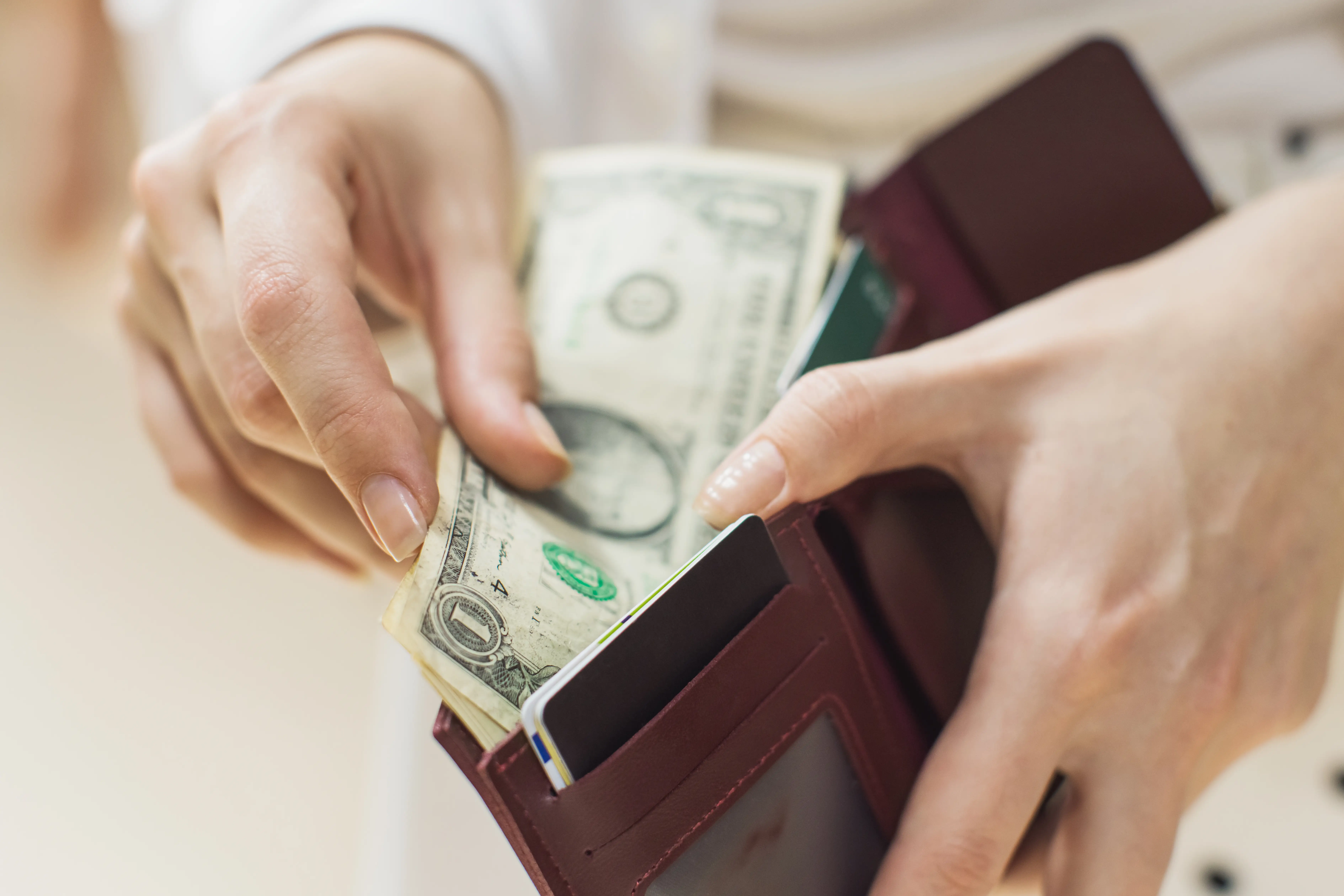 a woman pulling out dollars from her wallet