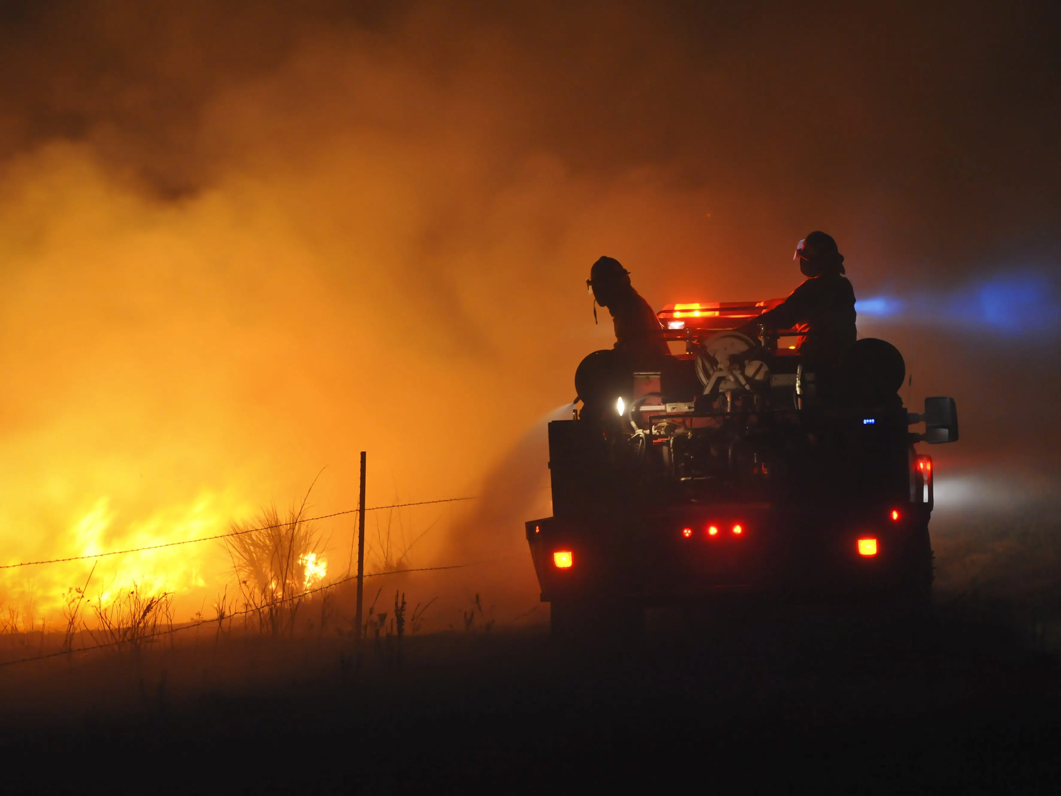 Firefighters watching a blaze while battling a fire near Springview, Nebraska.