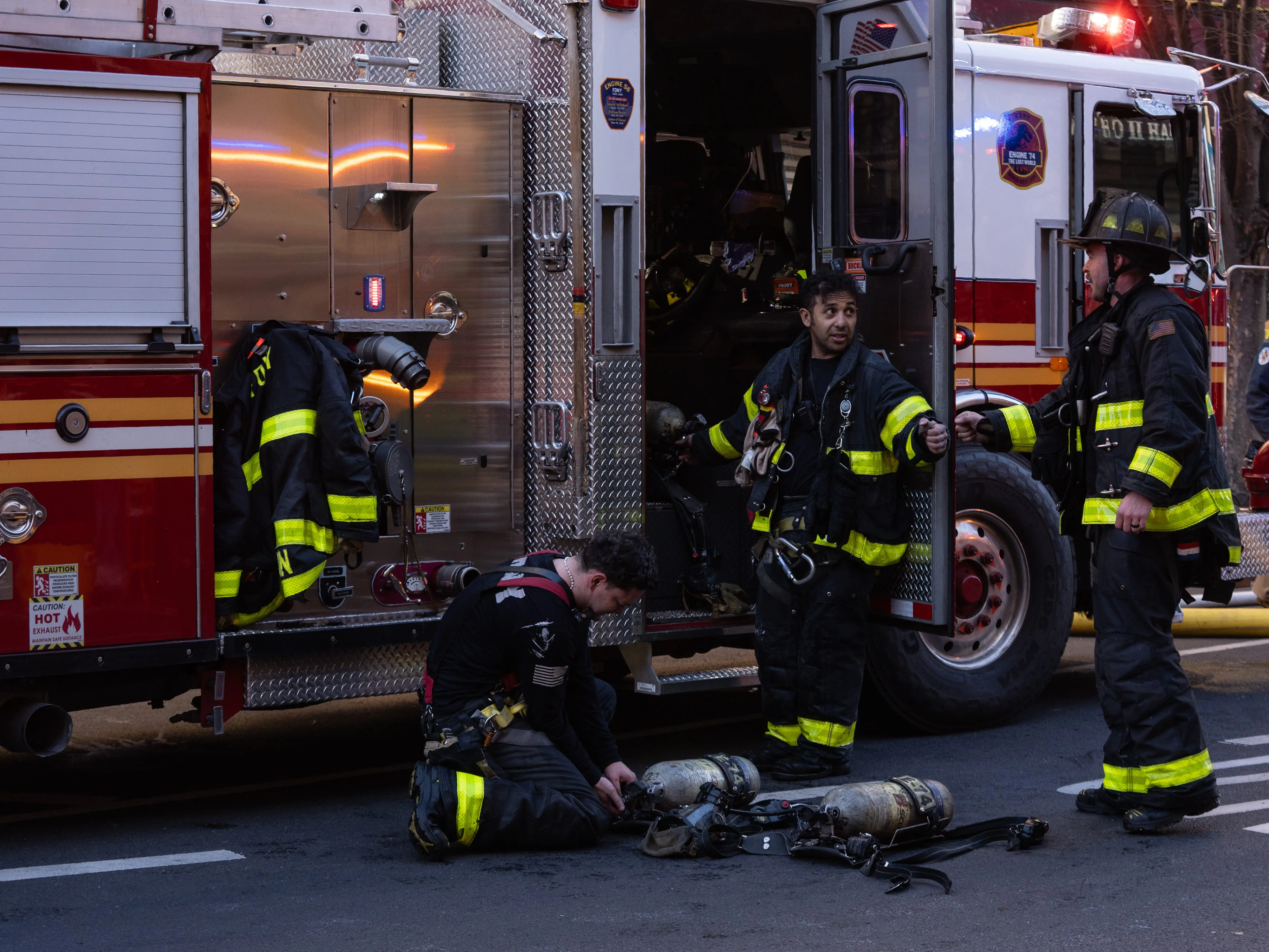 Firefighters talking next to a fire engine while responding to a fire in New York City.