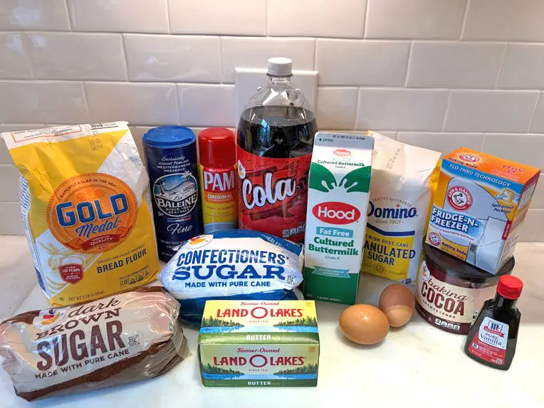 The full collection of ingredients for the chocolate-cola cake, including dark-brown sugar, cola, butter, eggs, and more.