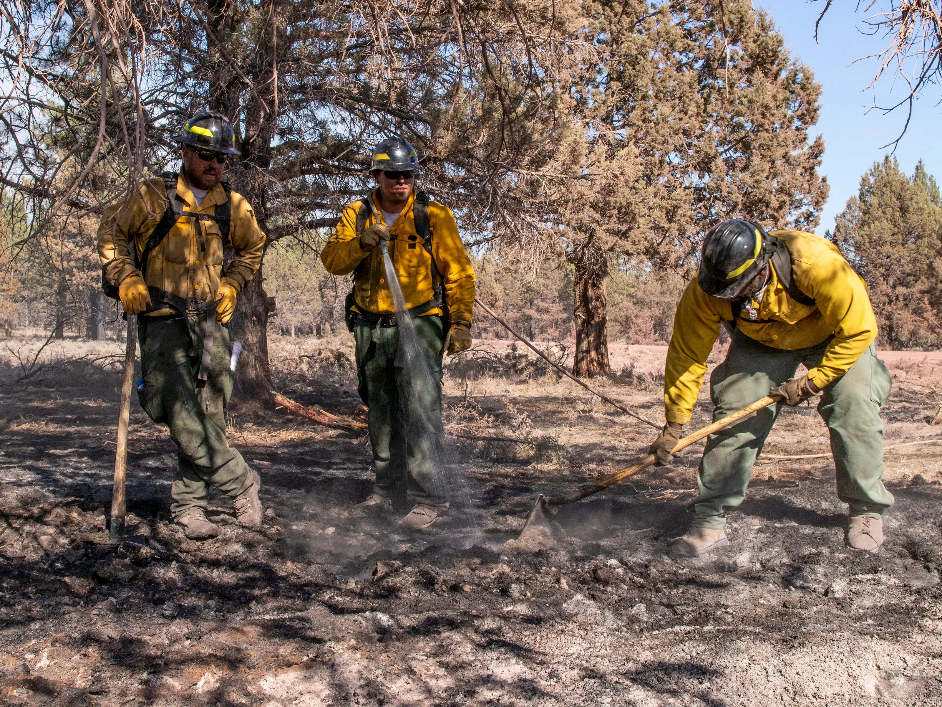 Three firefighters put out a hotspot after a wildfire northeast of Klamath Falls, Oregon.
