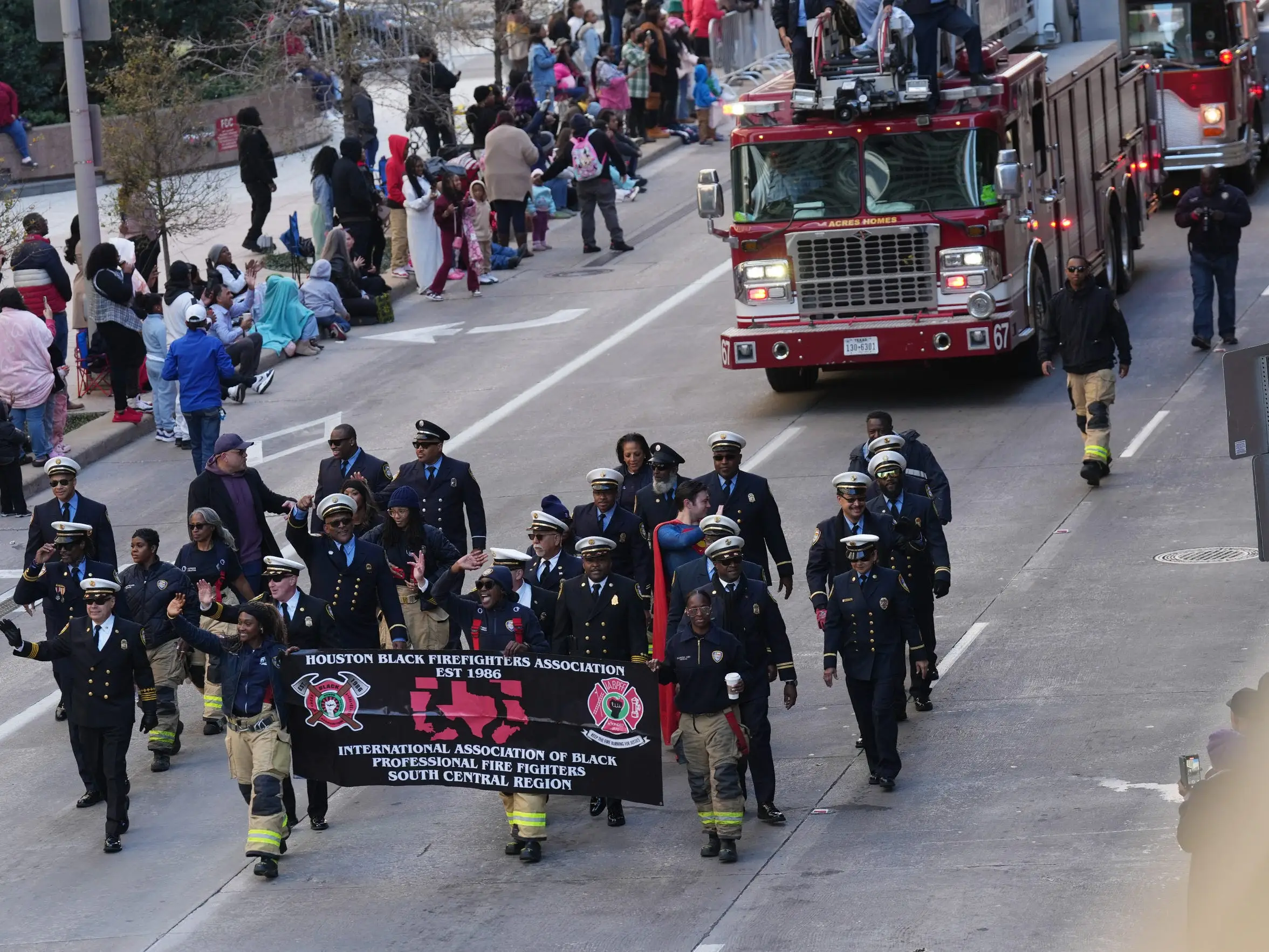 Firefighters marching in front of firetrucks in the Martin Luther King Jr. Unity Parade in Houston, Texas.