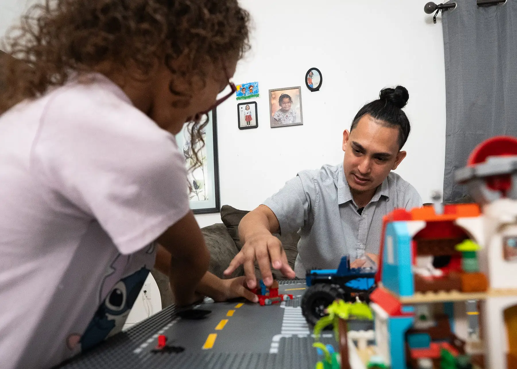 A man playing Legos with his daughter.