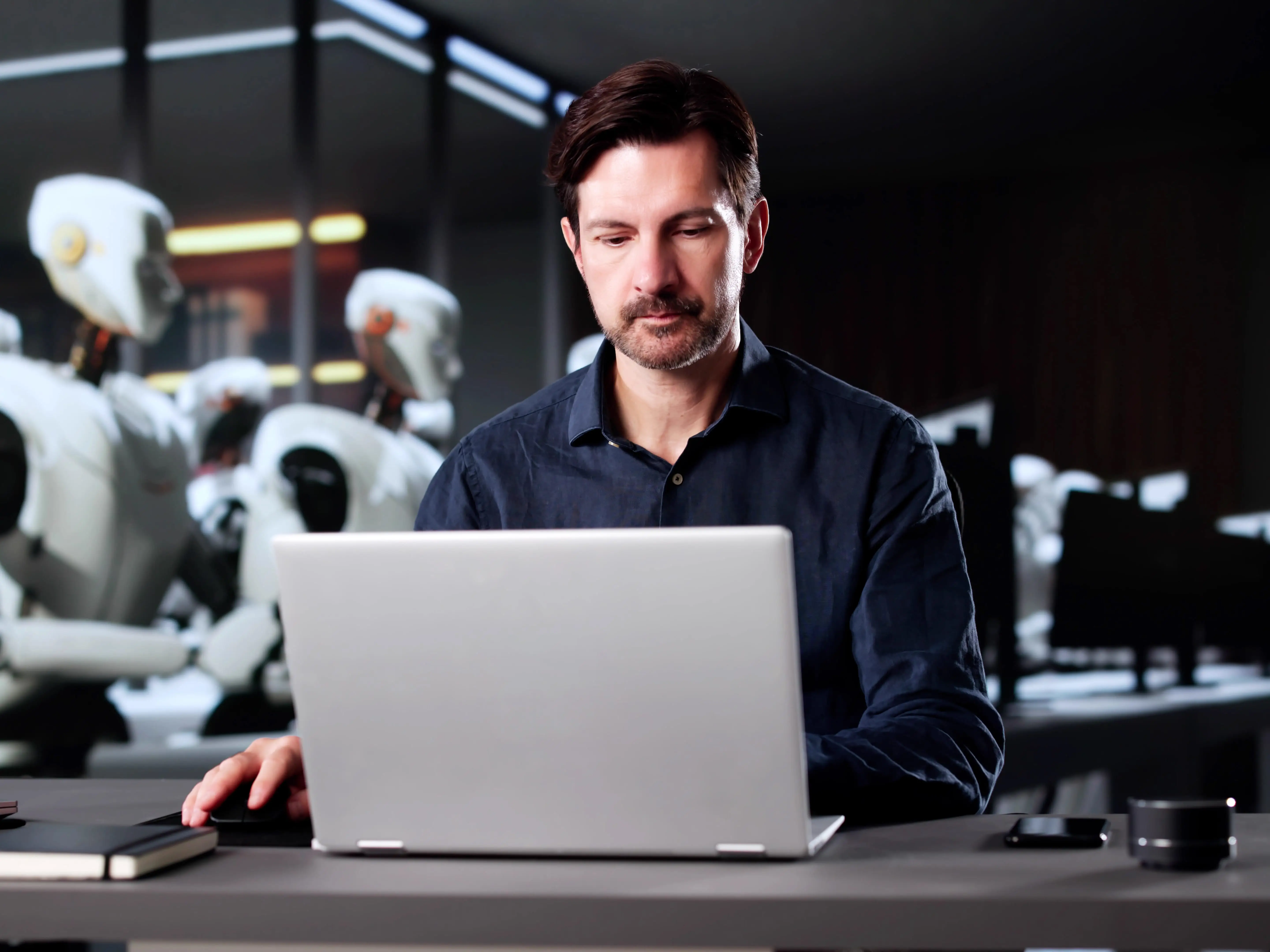 Person at computer with robots in the background