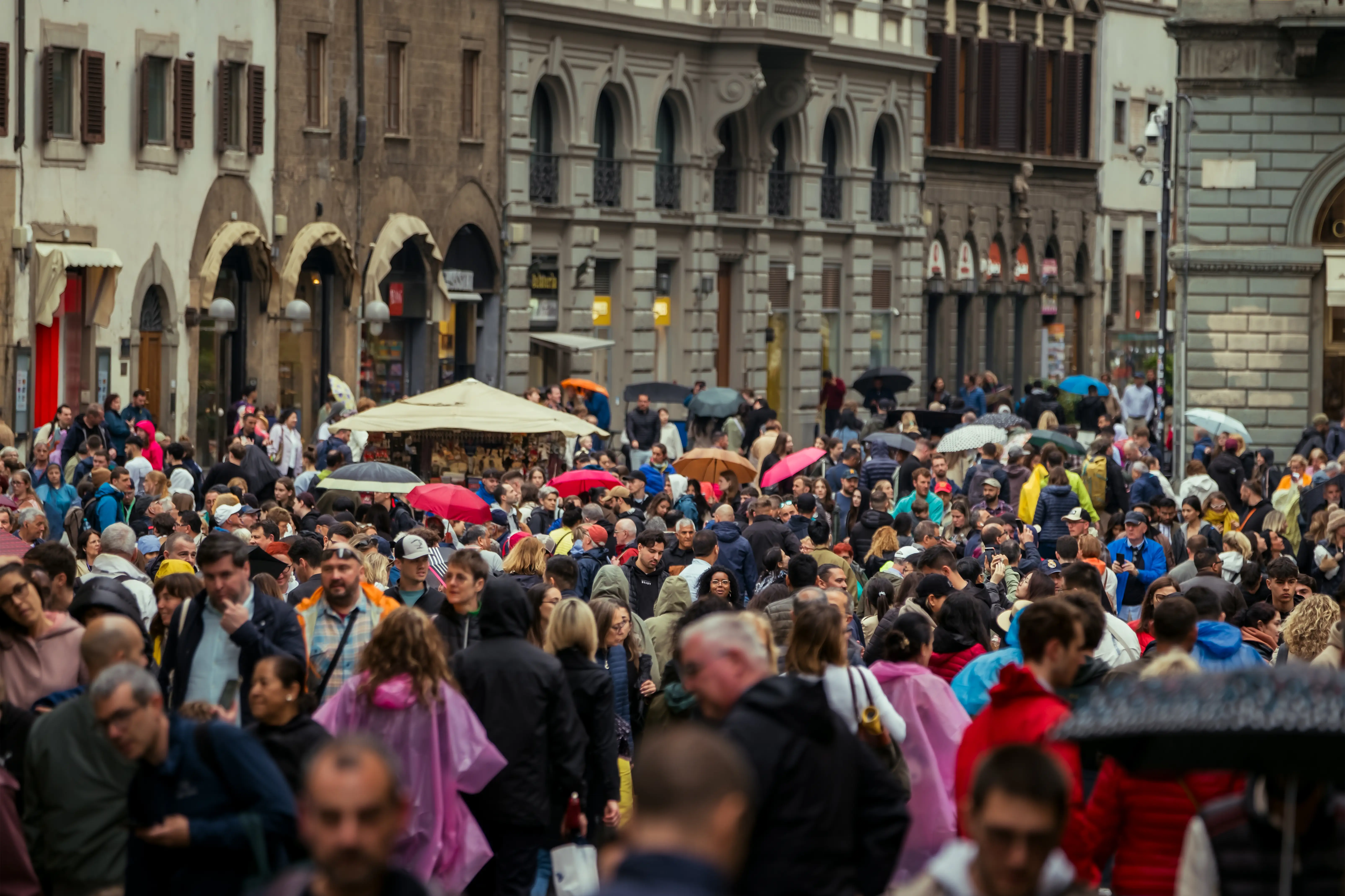 Crowds of people in Florence, some with umbrellas