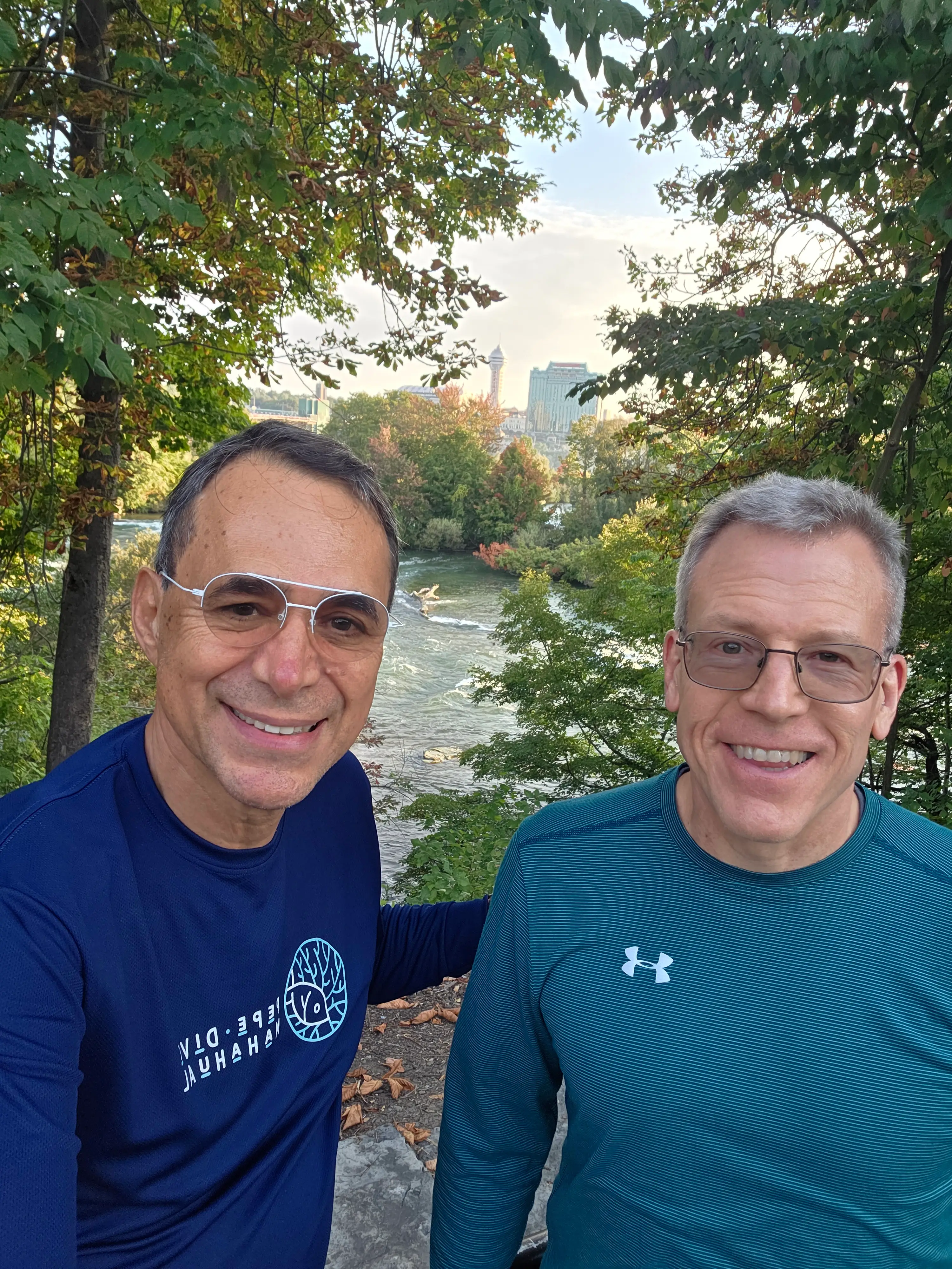 Scovel and his friend Bruno are standing in front of a lake and trees.