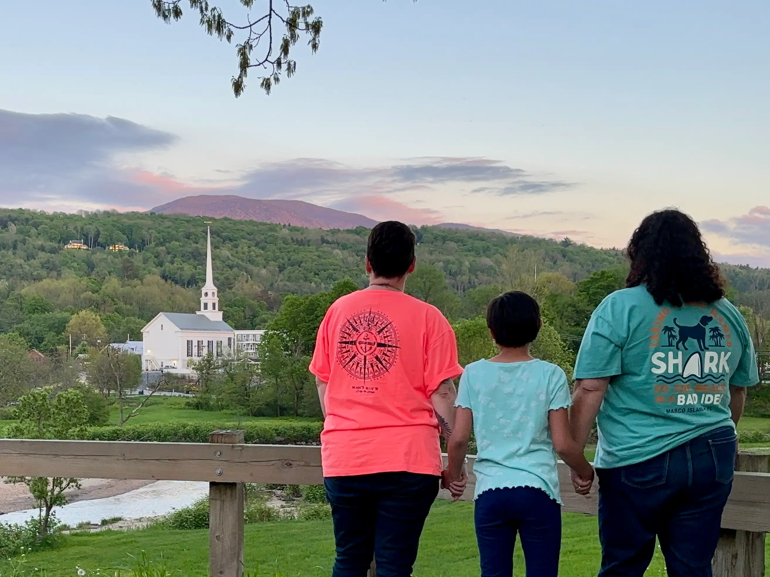 Three people staring at mountains