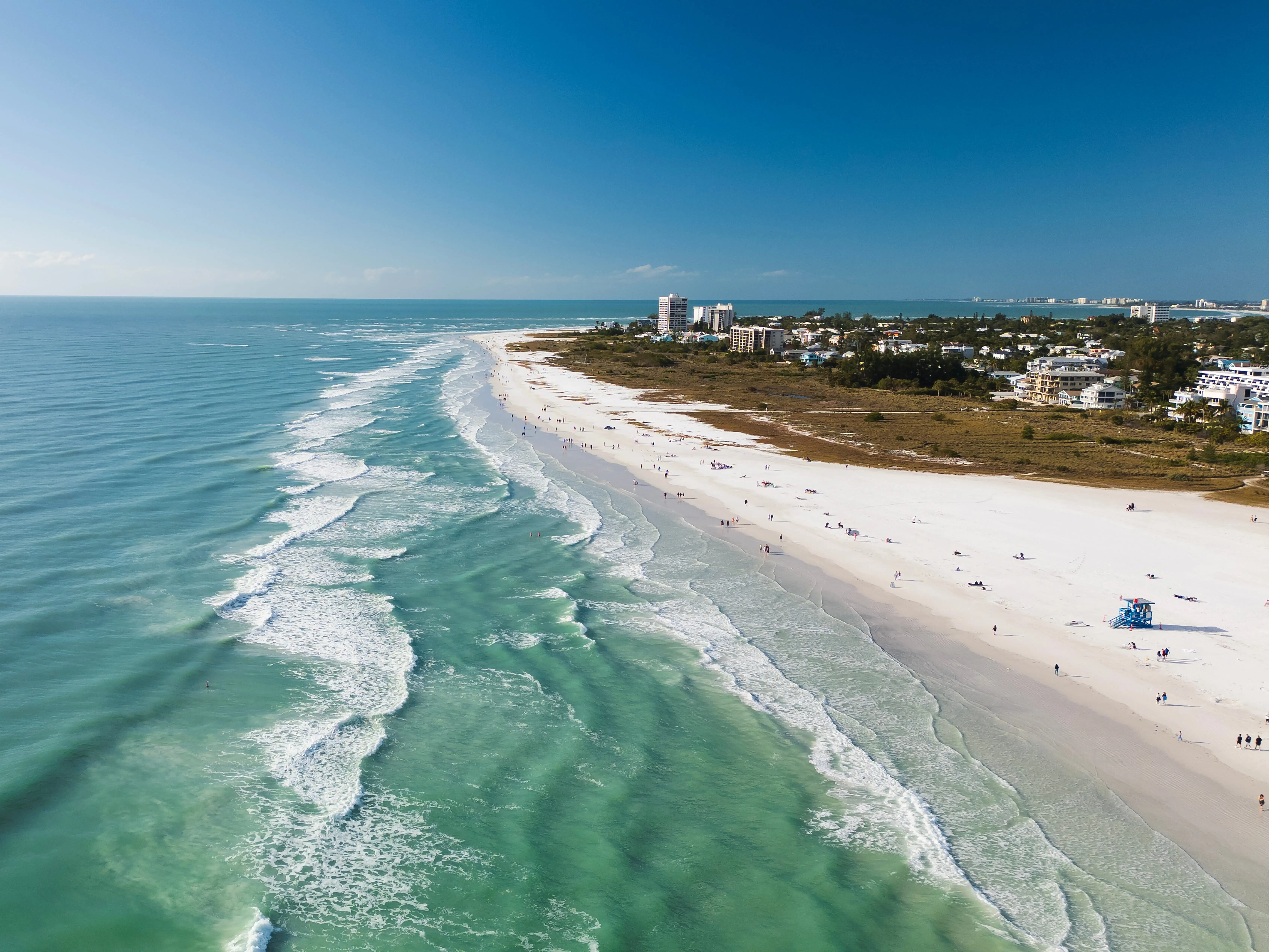 Drone Fly view over beach in Siesta Key,  Florida. Beautiful Siesta Key beach on a sunny day. Turquoise transparent water and blue sea in Siesta Key beach.