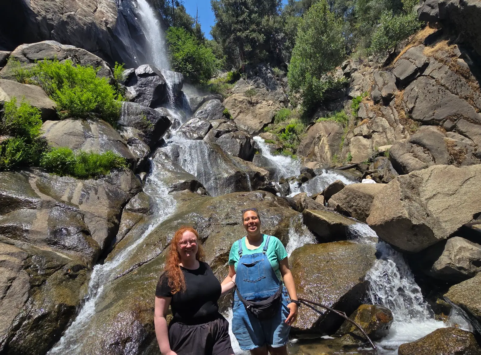 The writer and her best friend in front of a waterfall in Kings Canyon.