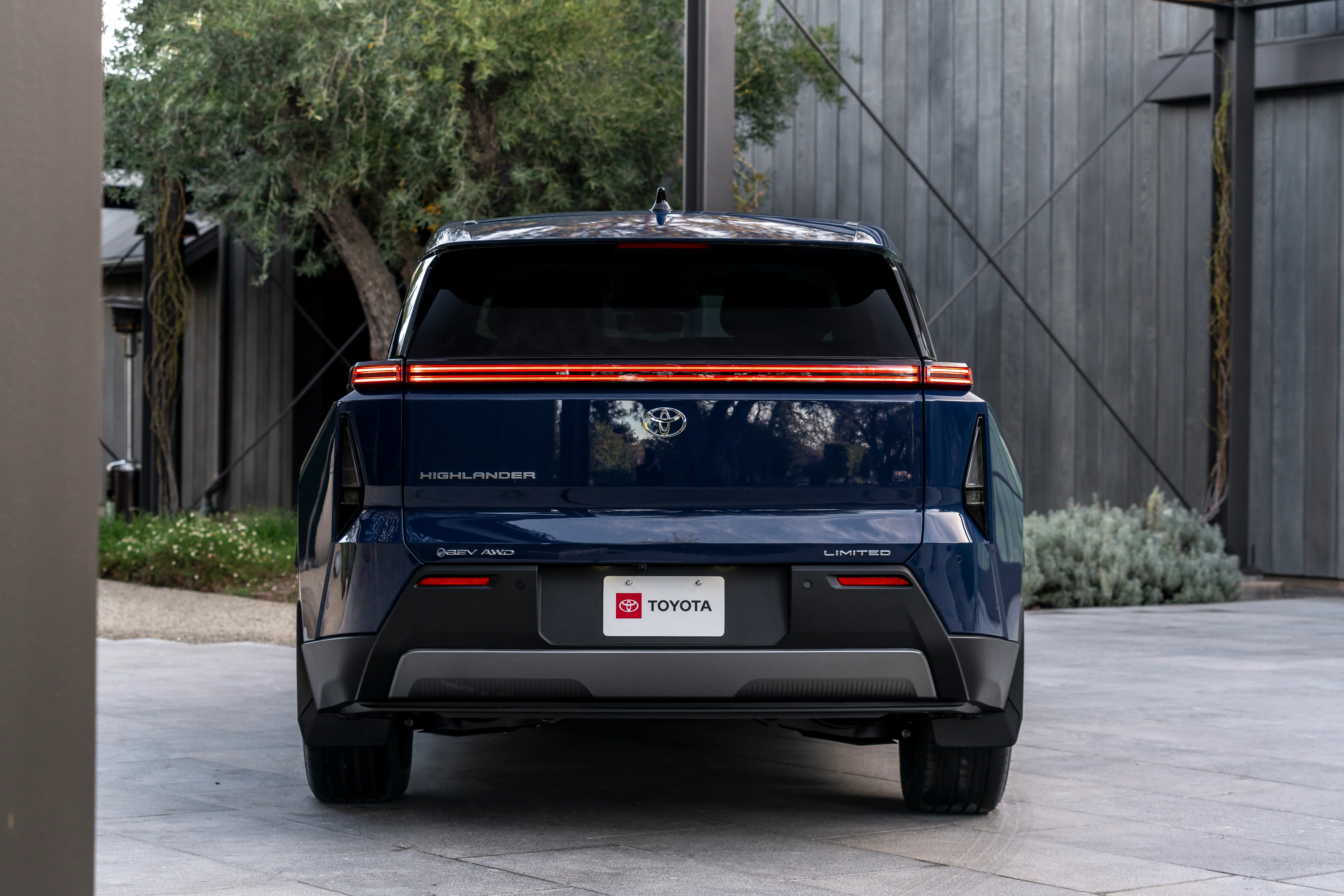 The back of a blue Highlander EV with a Limited badge.