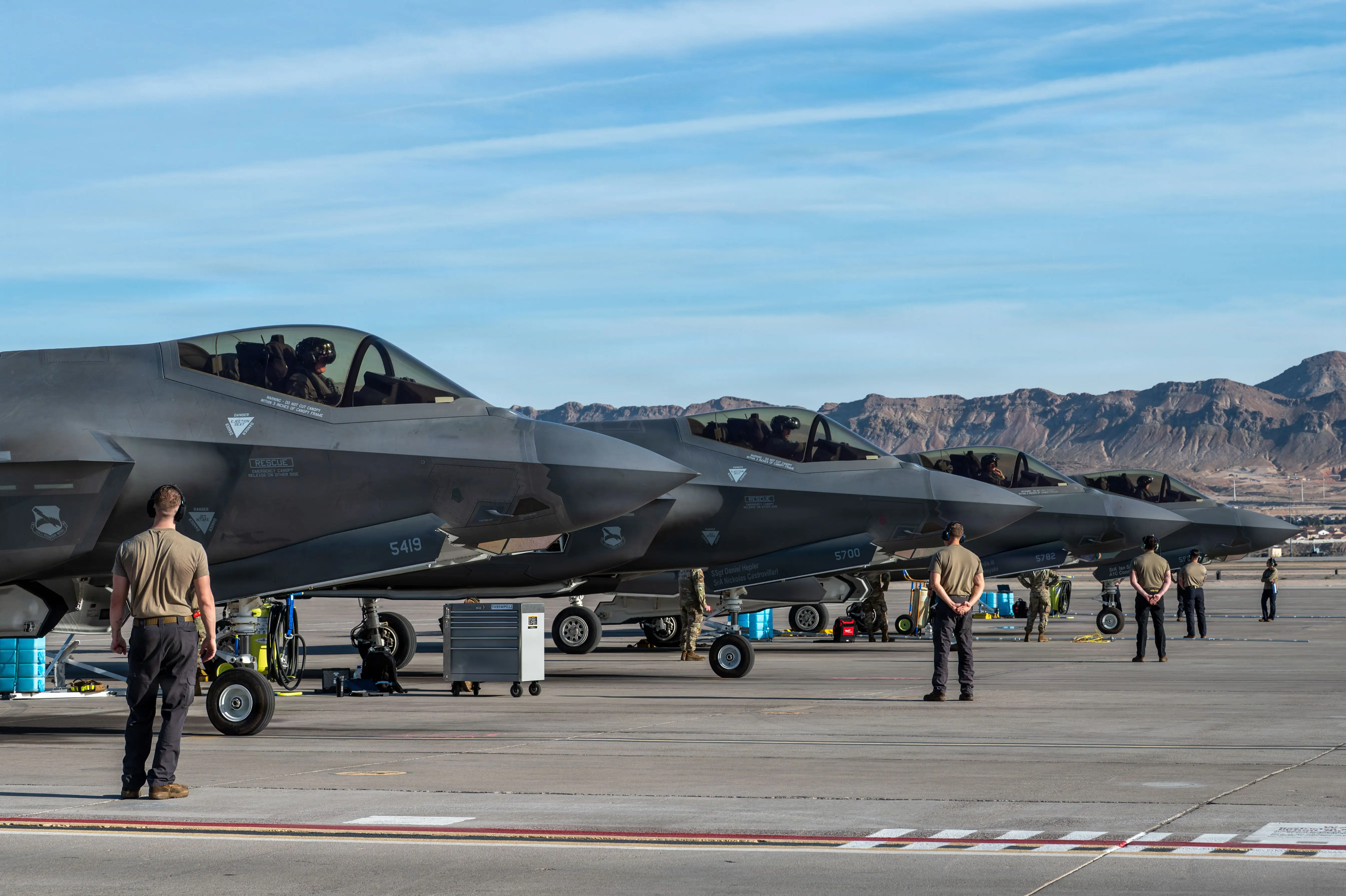 A row of four F-35A fighters sit parked on tarmac.