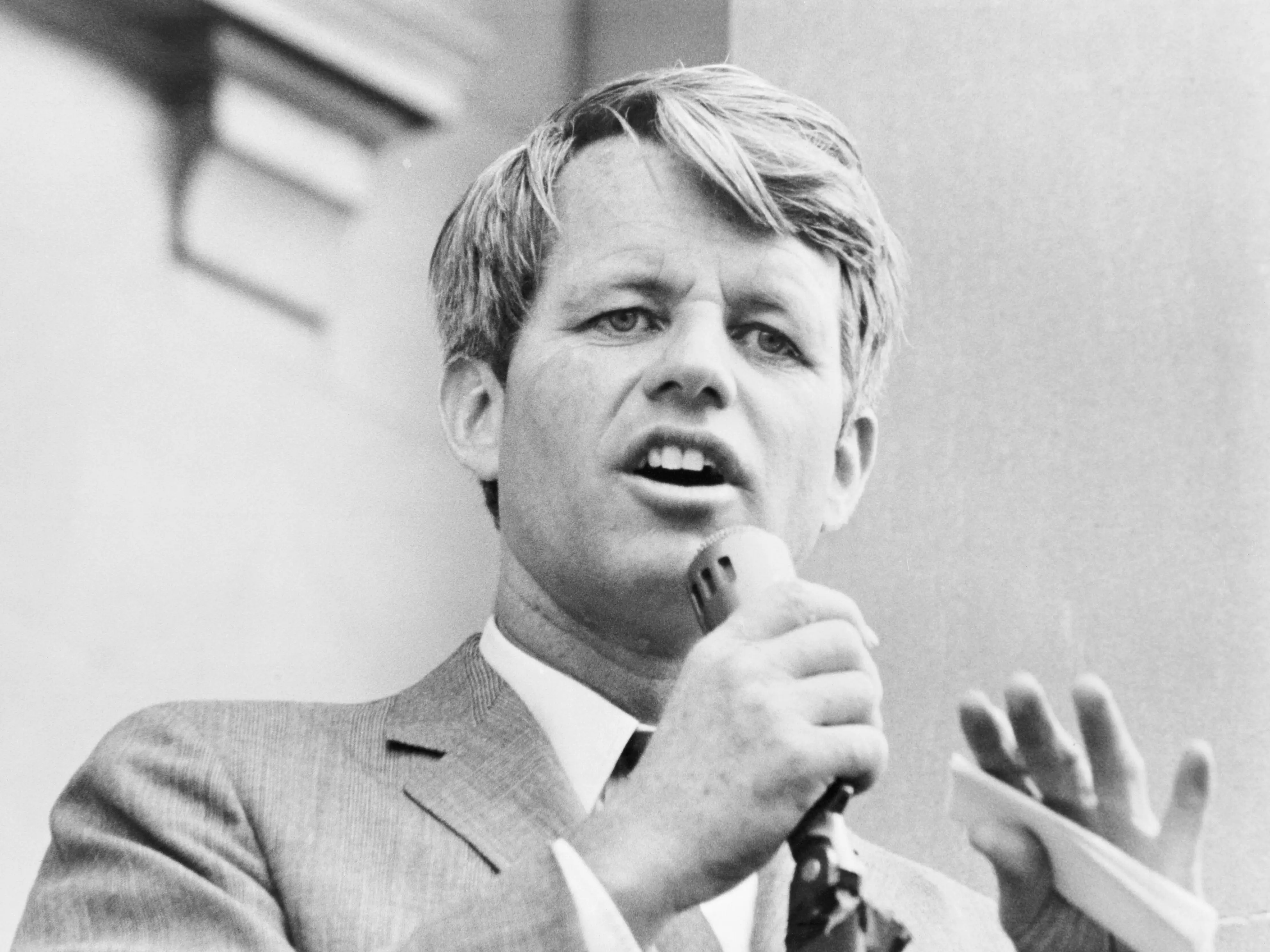 Robert F. Kennedy speaks into a microphone.