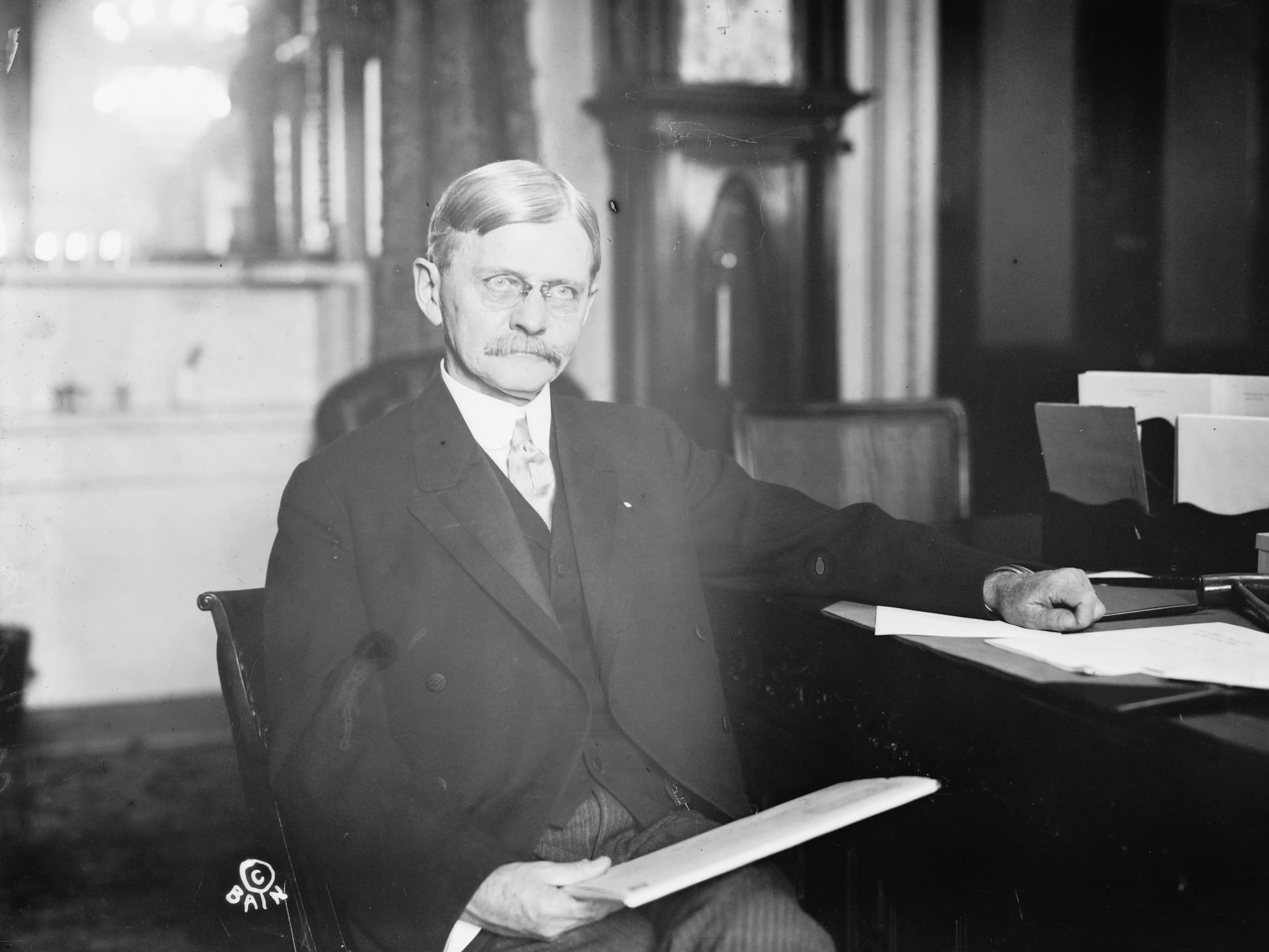 Thomas R. Marshall sitting at a desk.