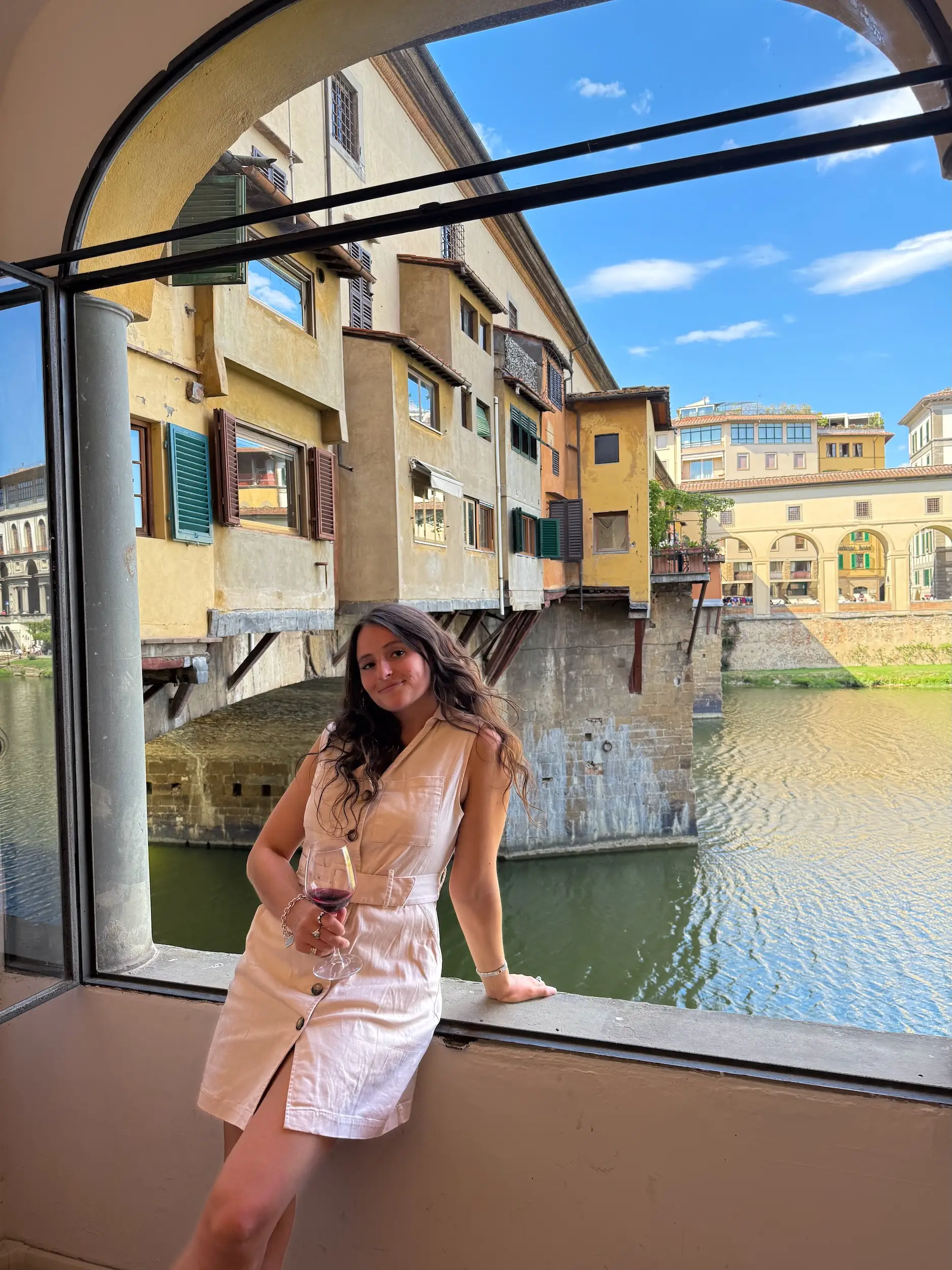 A woman posing in front of a waterway in Italy.