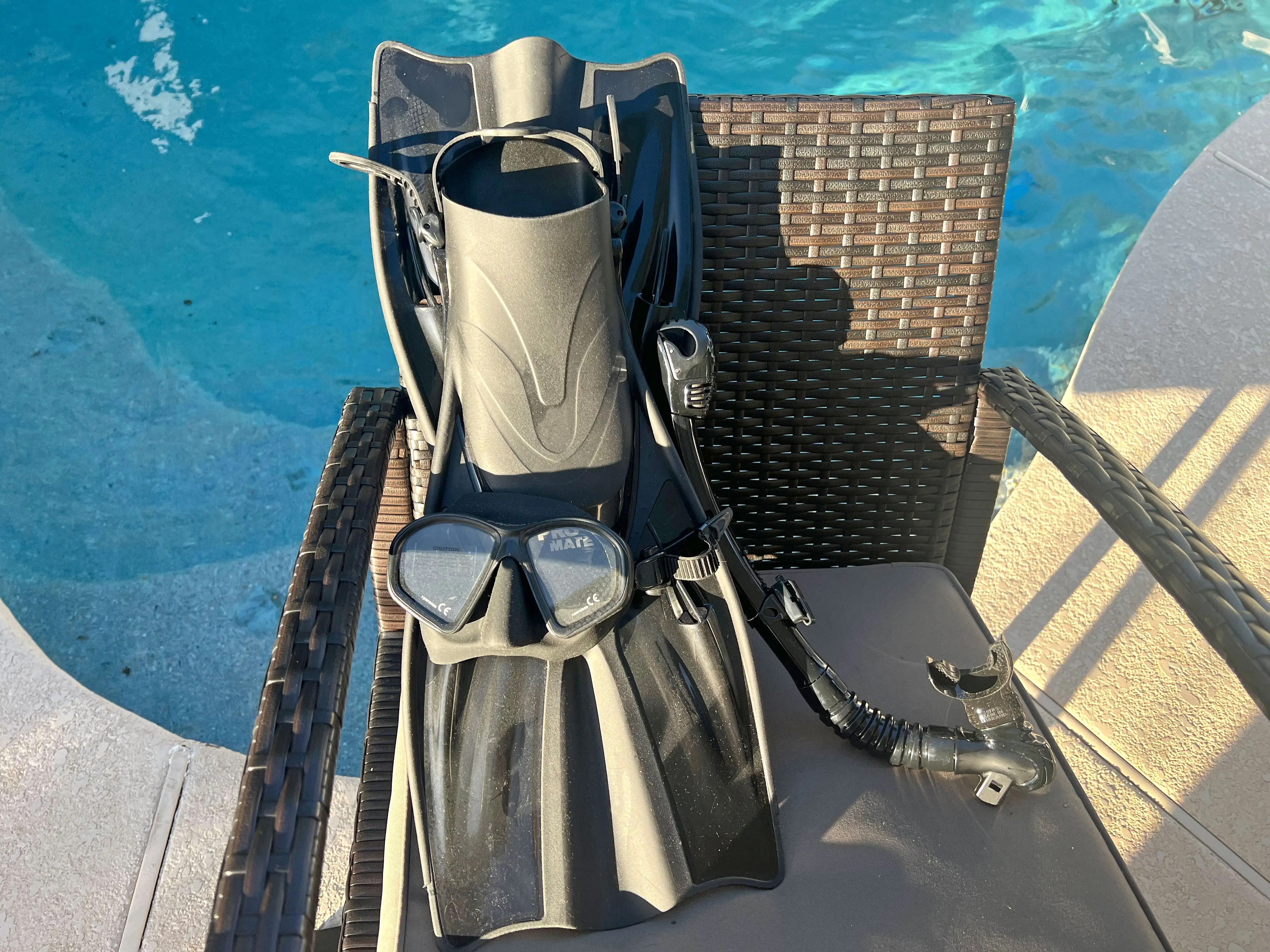 Snorkeling equipment on a chair near a pool.