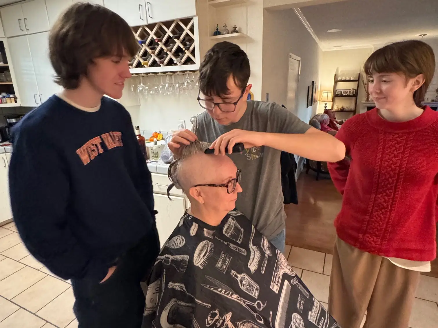 Woman getting hair shaved by kids