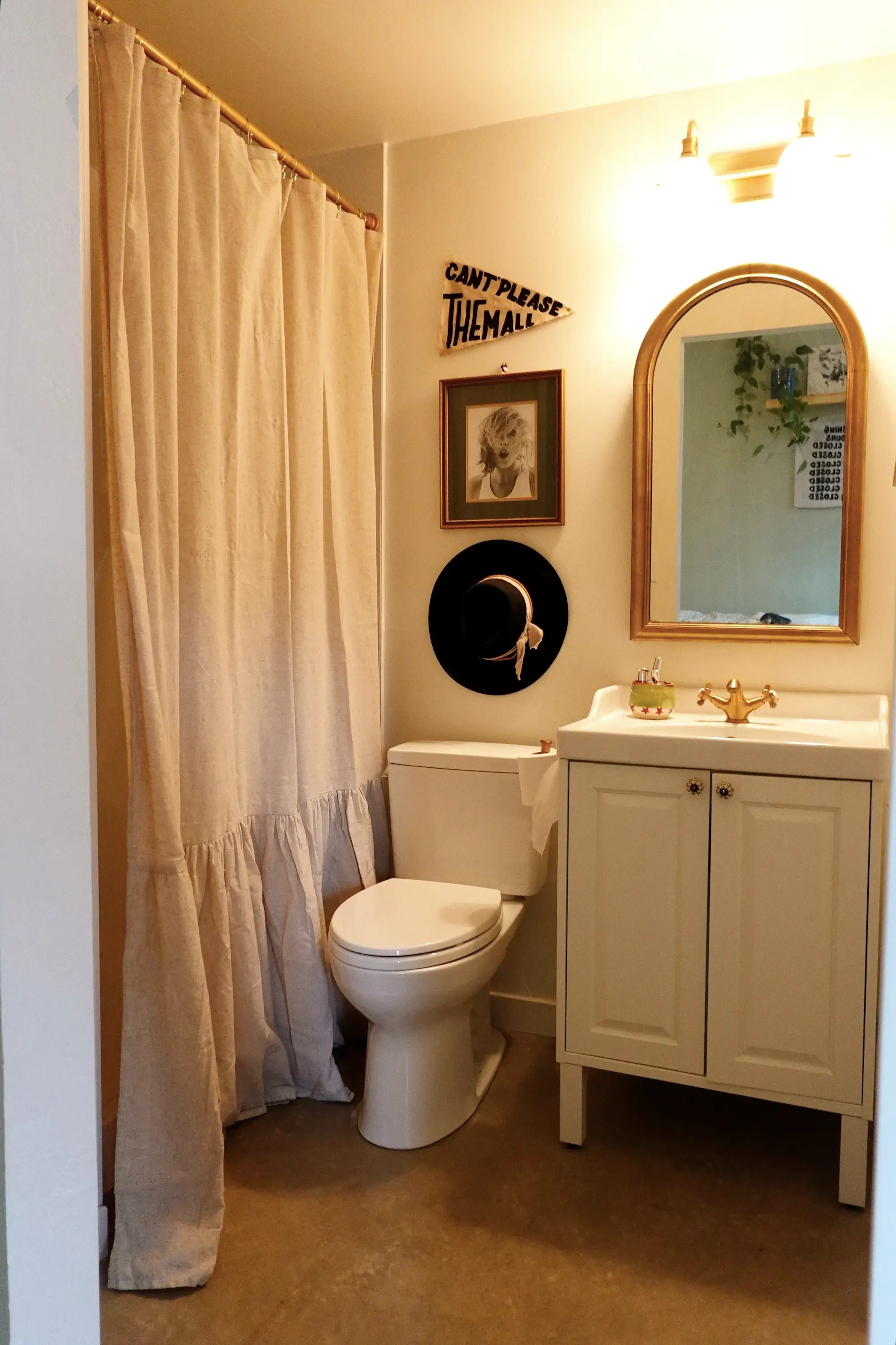 A bathroom with a ruffled shower curtain and white vanity.