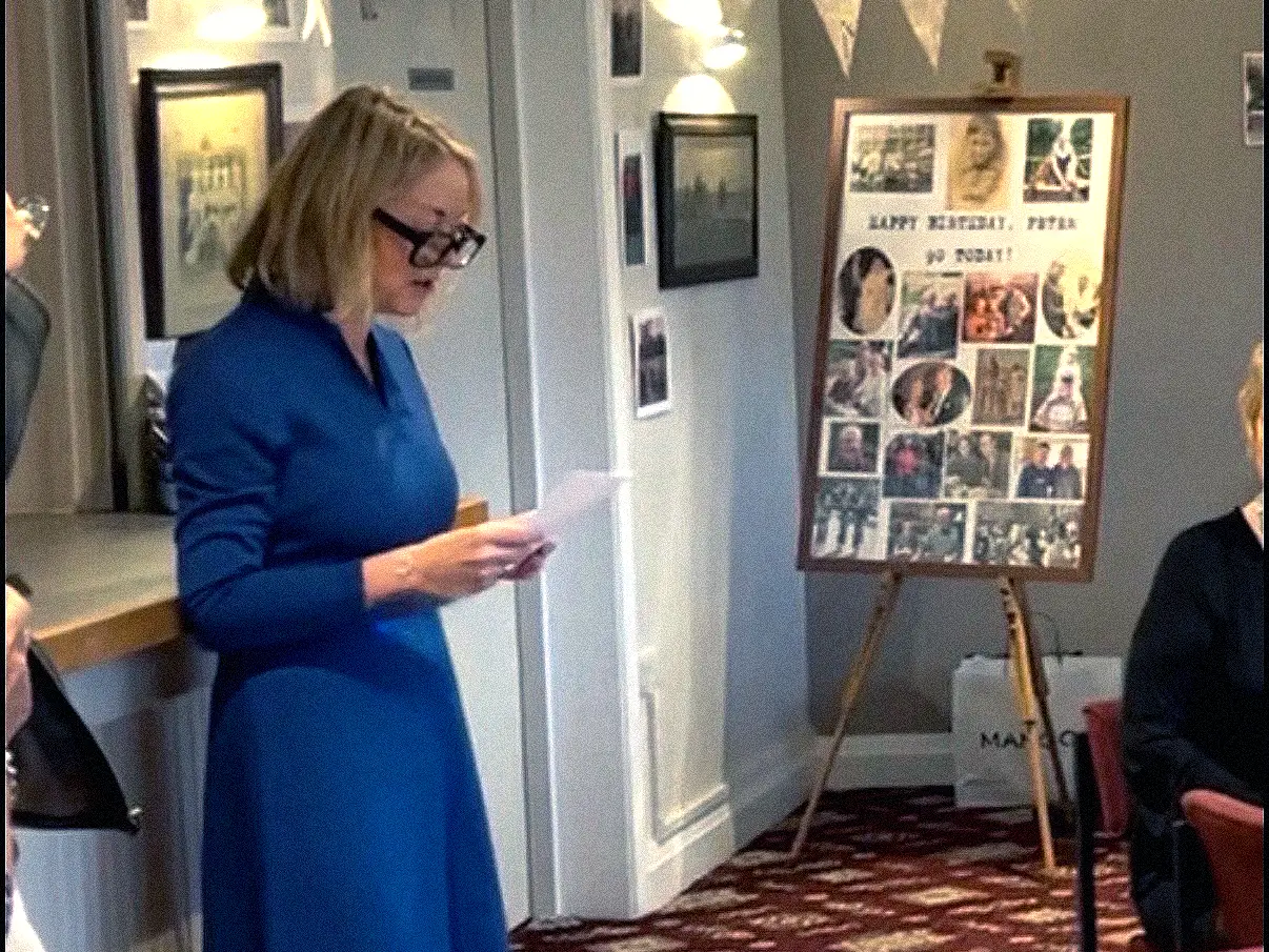 A woman in a blue dress making a speech