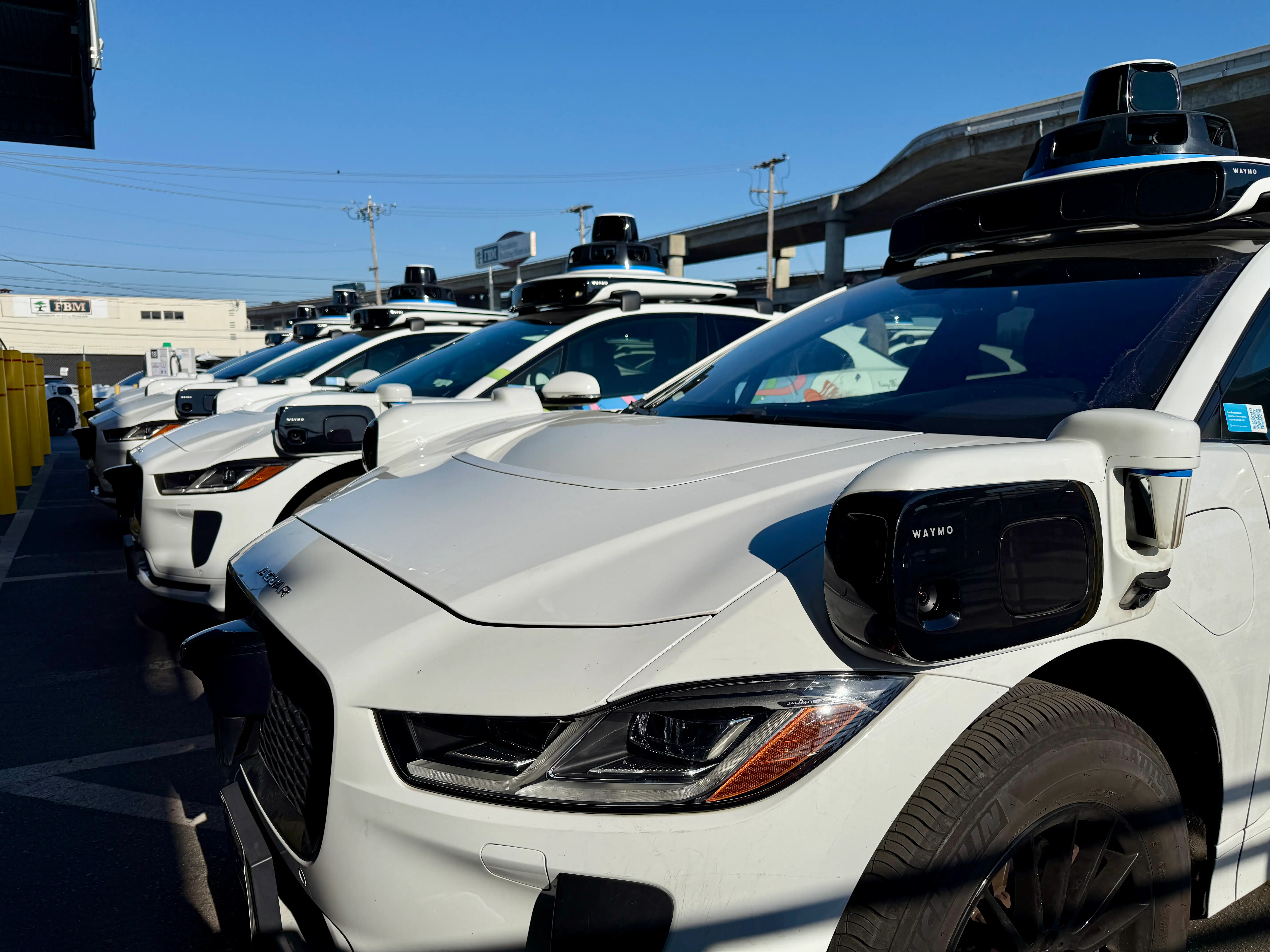 A row of Waymo robotaxis