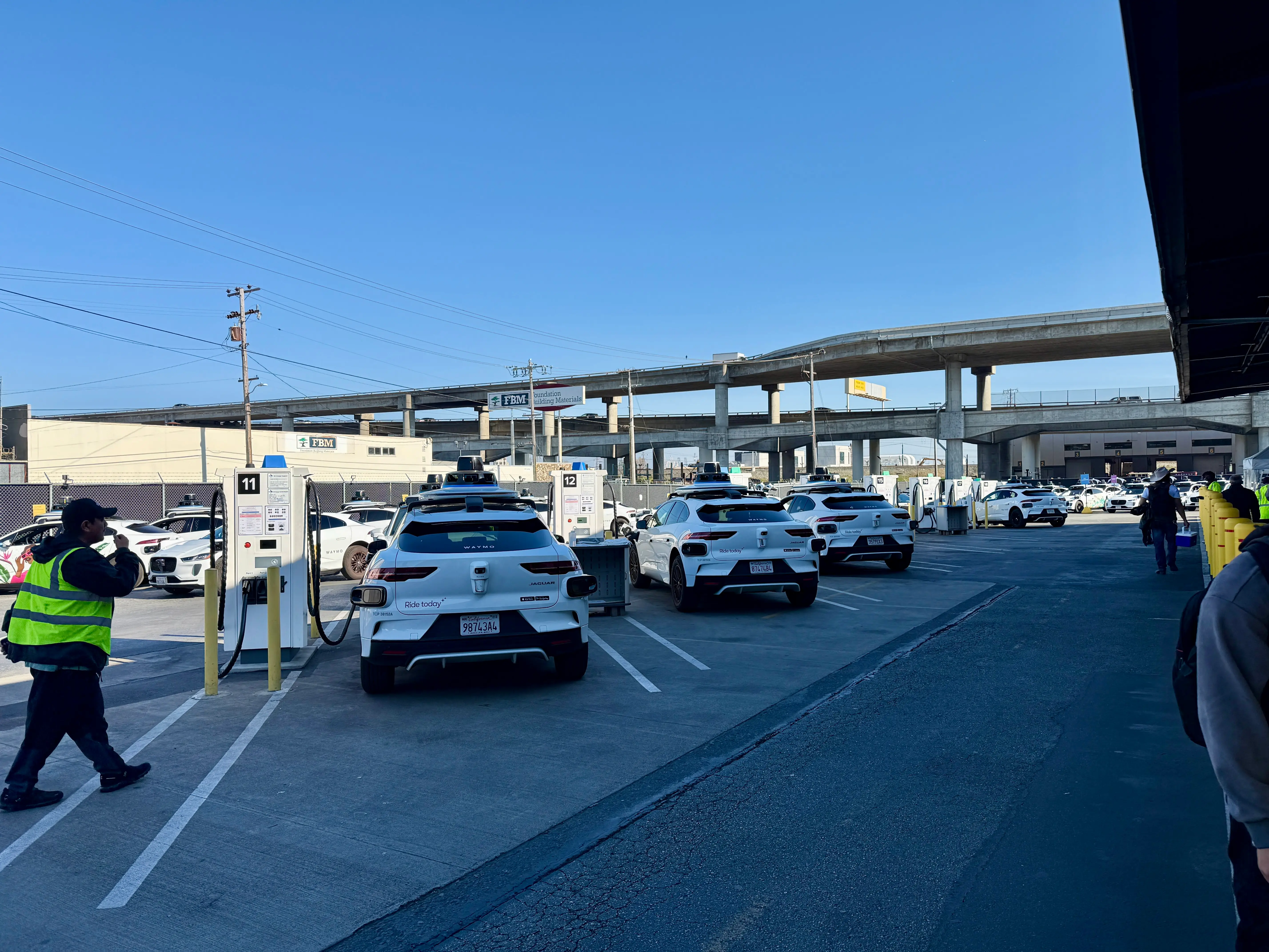 A row of Waymos parked