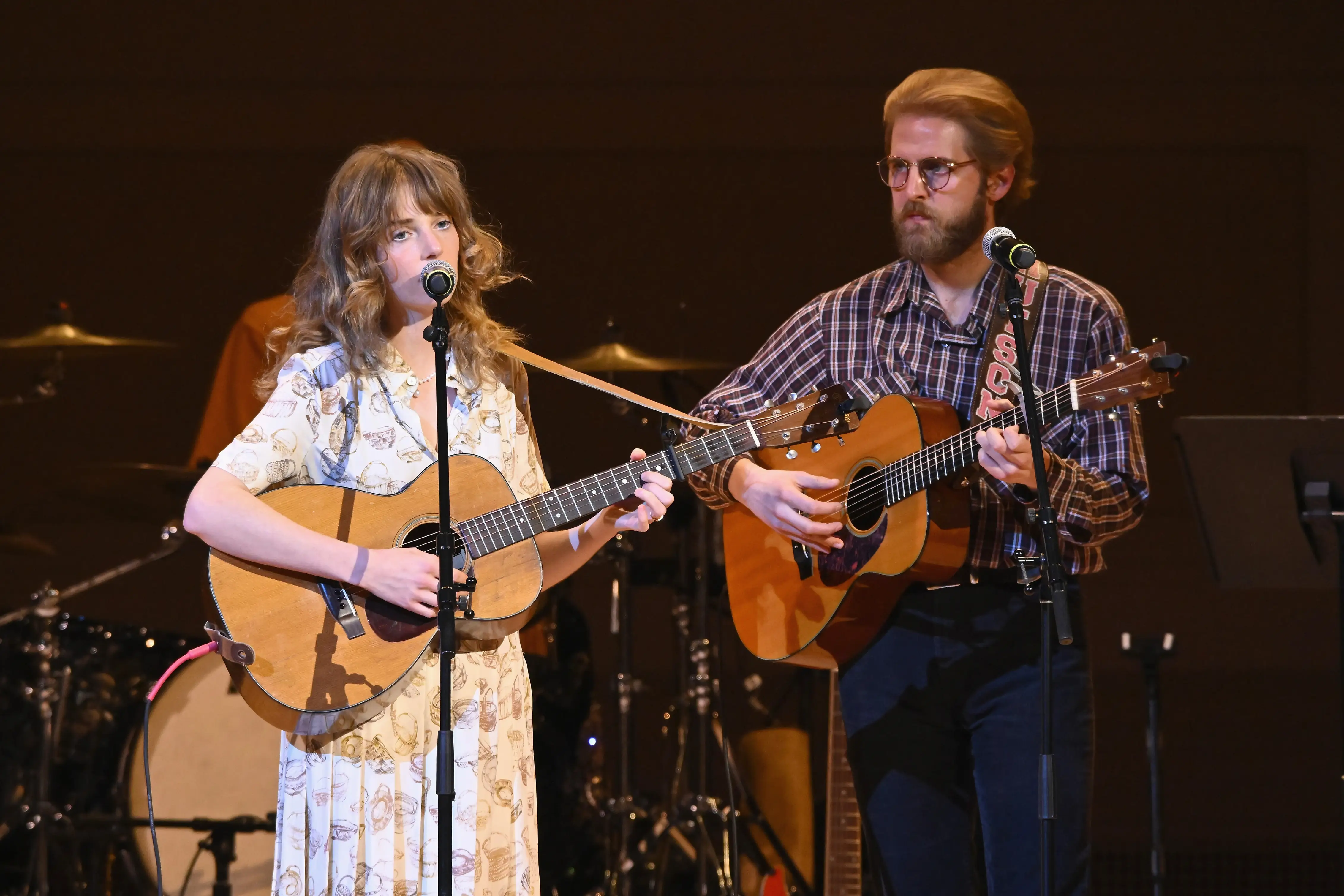 Maya Hawke and Christian Lee Hutson performing with guitars on stage