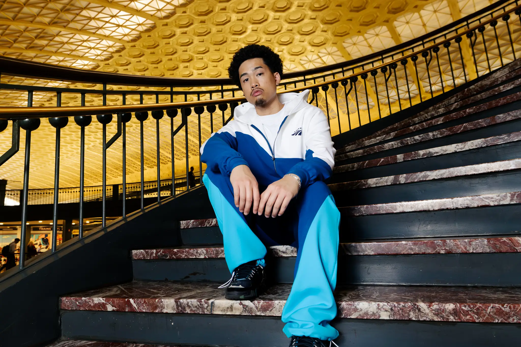 A model wears the Amtrak 'Trak Suit on a staircase