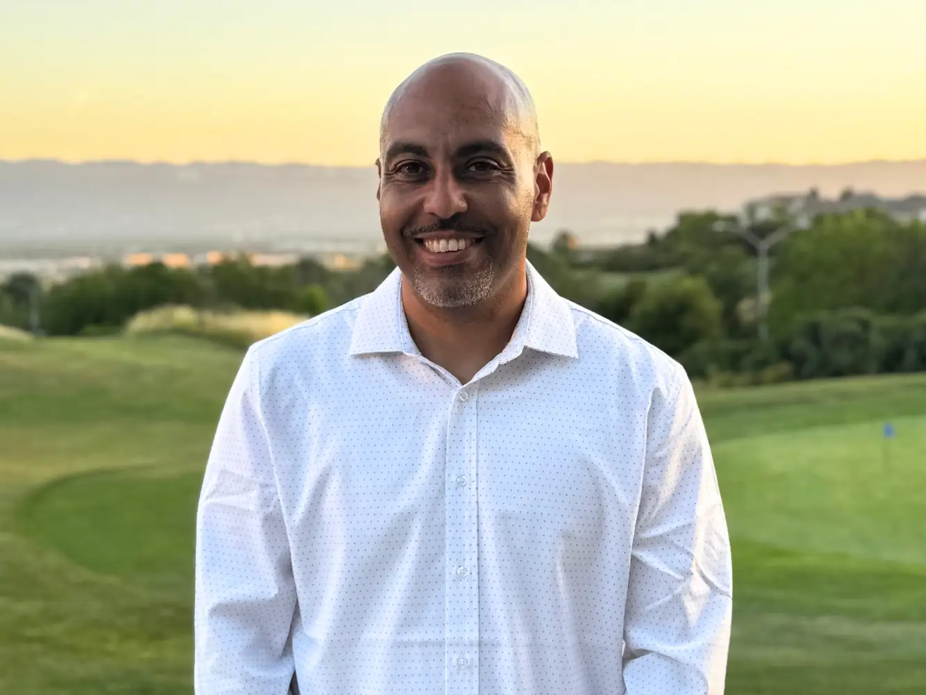Brian Jenney wearing a white shirt, standing on a golf course