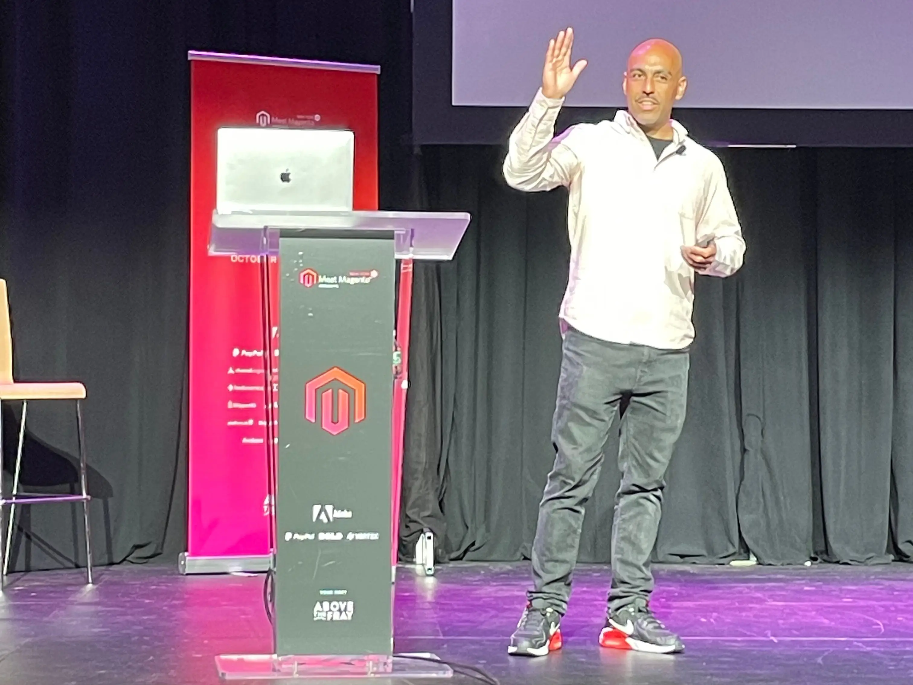 Brian Jenney is standing on a stage giving a talk.