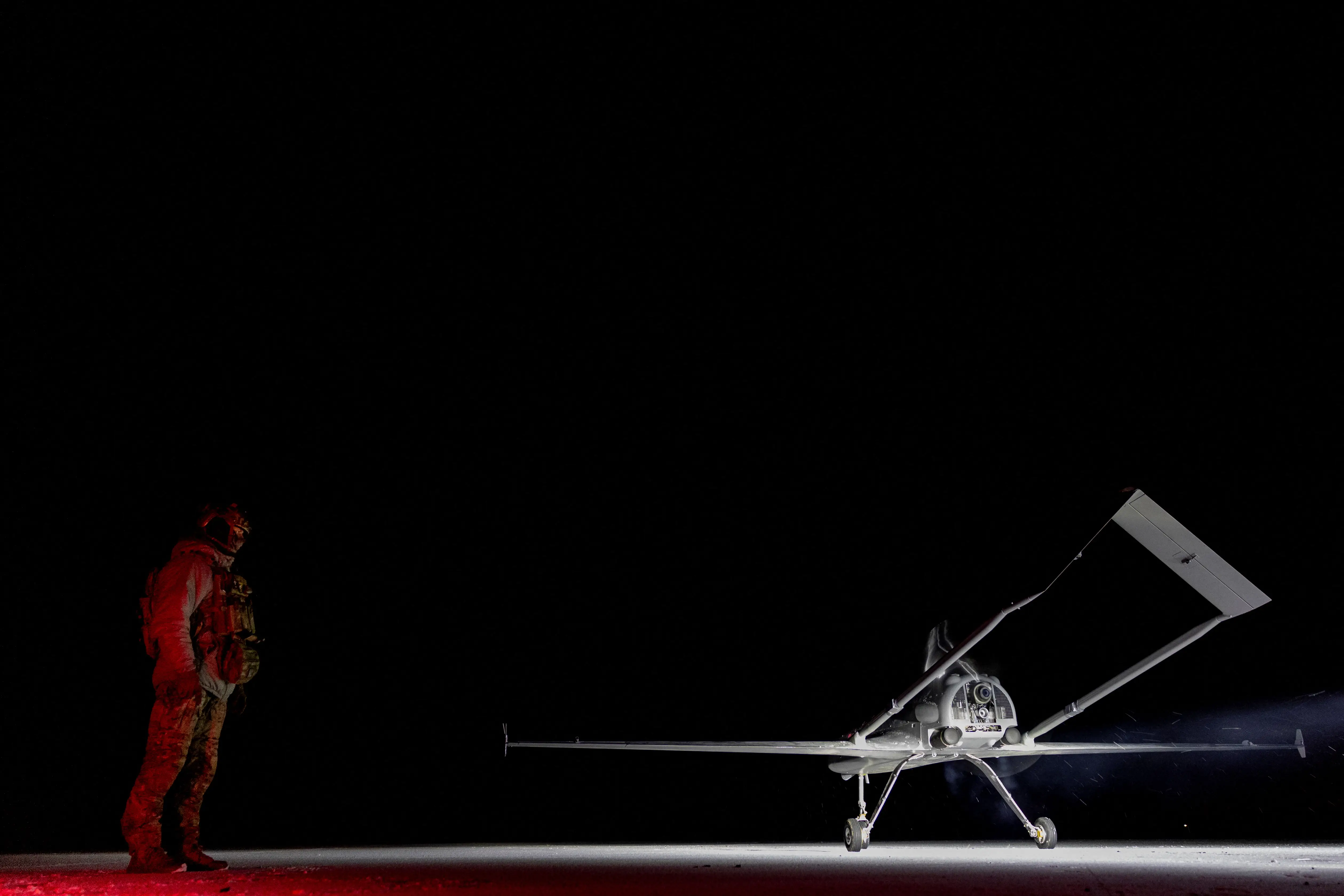 A Ukrainian serviceman with the call sign 'Kasper,' member of the 14th Unmanned Aerial Systems Regiment, stands next to a deep strike unmanned aerial vehicle before its launch towards Russian territory, amid Russia's attack on Ukraine, in an undisclosed location in Ukraine, undisclosed date, 2025.