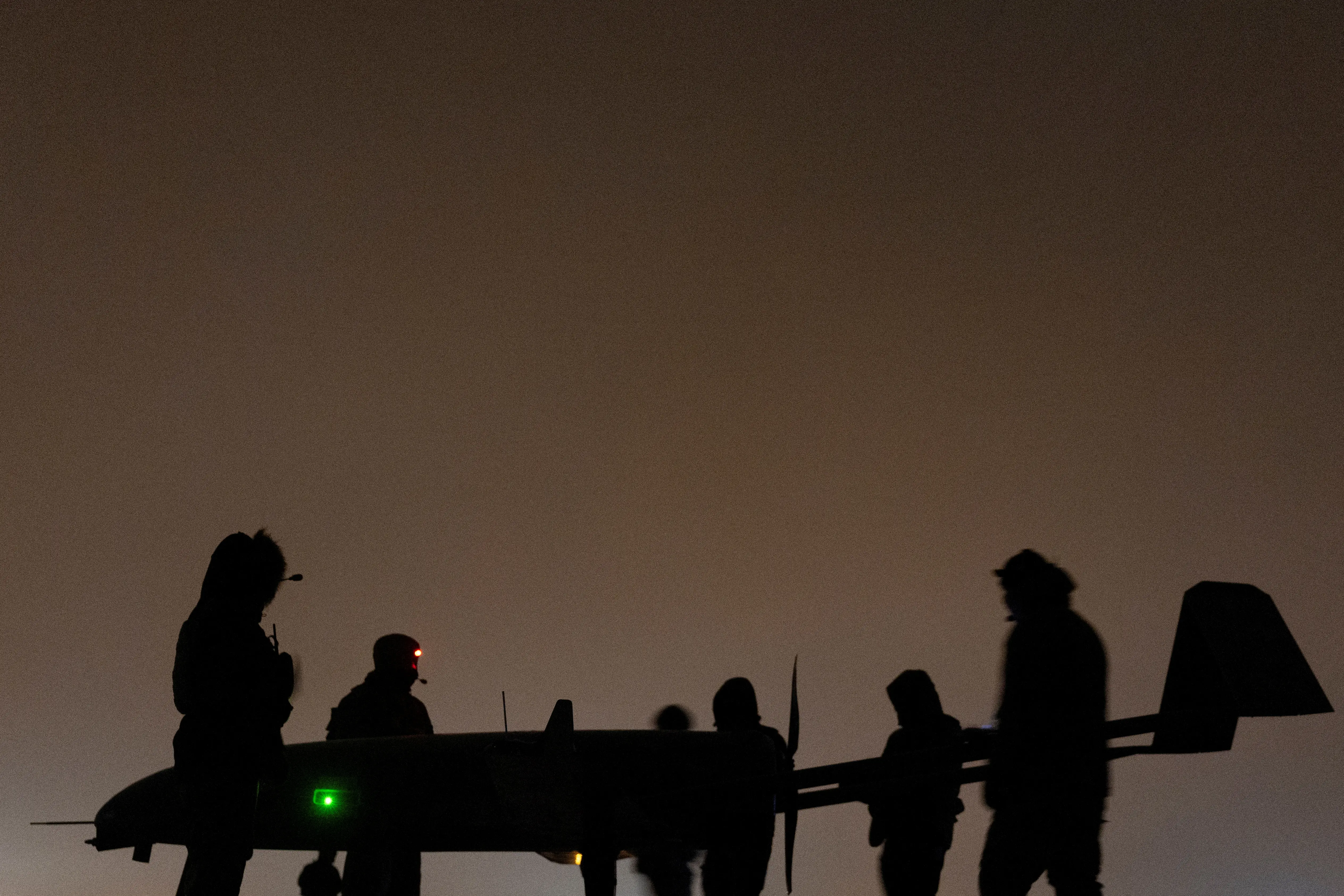 Ukrainian service members of the 14th Unmanned Aerial Systems Regiment stand next to a deep strike unmanned aerial vehicle before its launch toward Russian territory, amid Russia's attack on Ukraine, in an undisclosed location in Ukraine, undisclosed date, 2025.