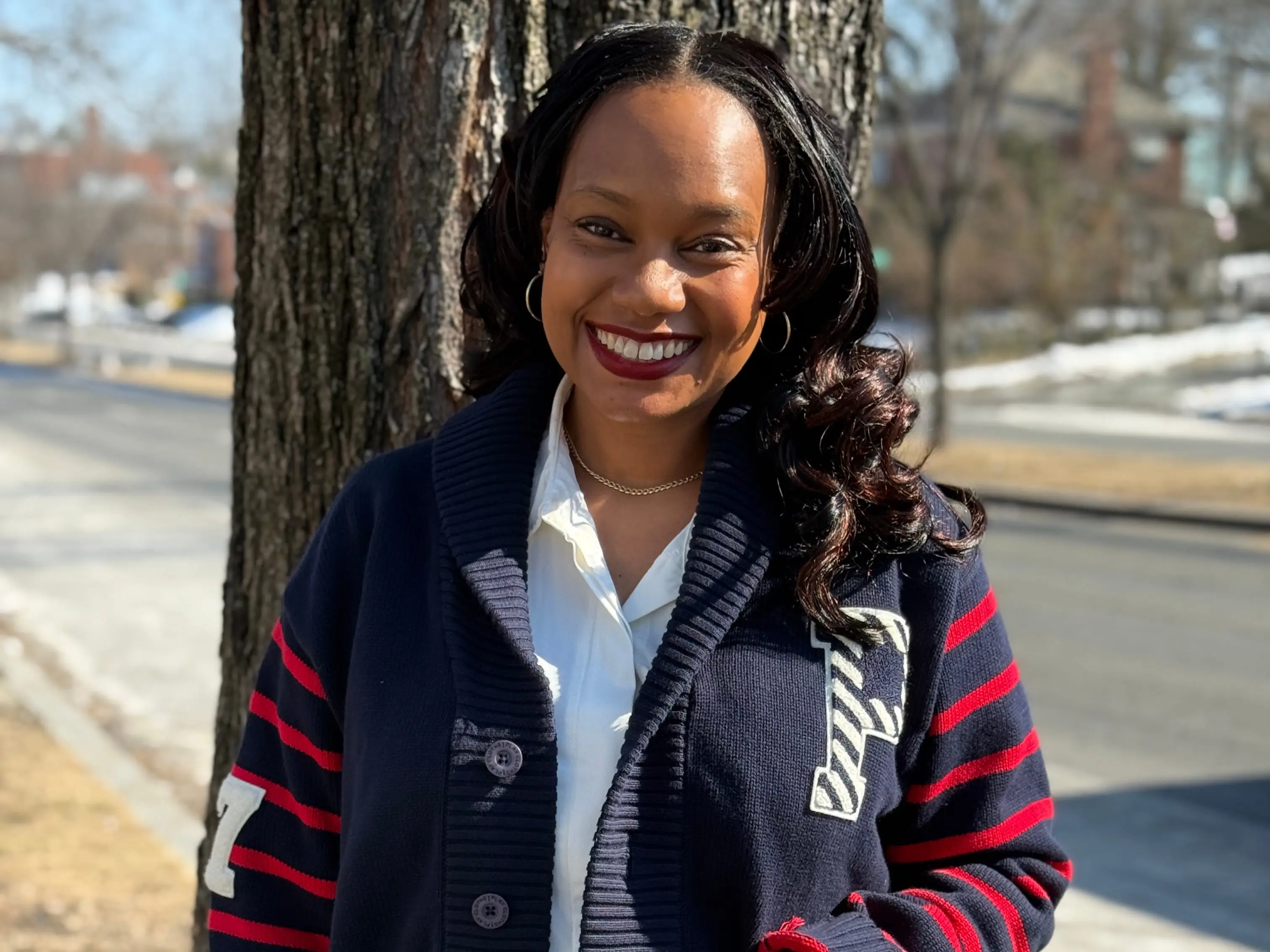 A woman wearing a blue cardigan and jeans.