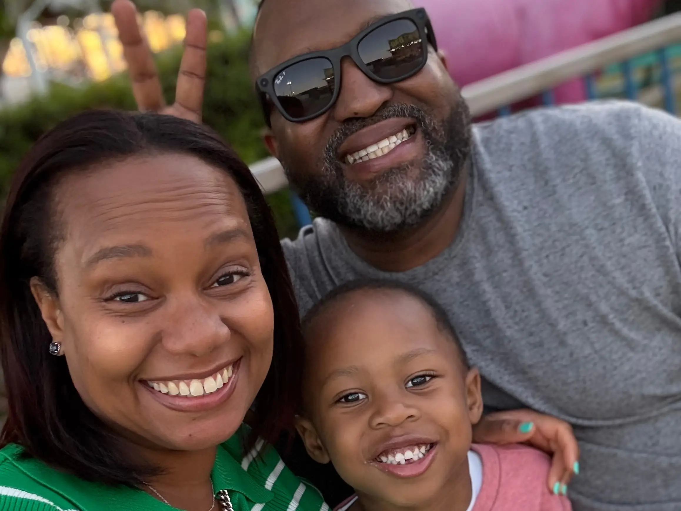 A family of three posing for a selfie.