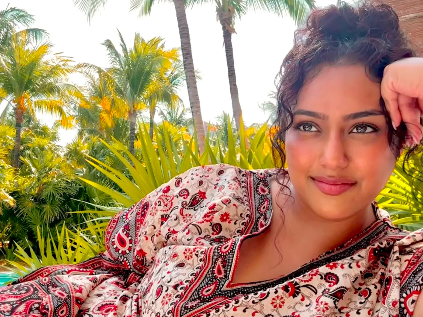 The writer lounging in front of the pool on a solo trip in Cancún.