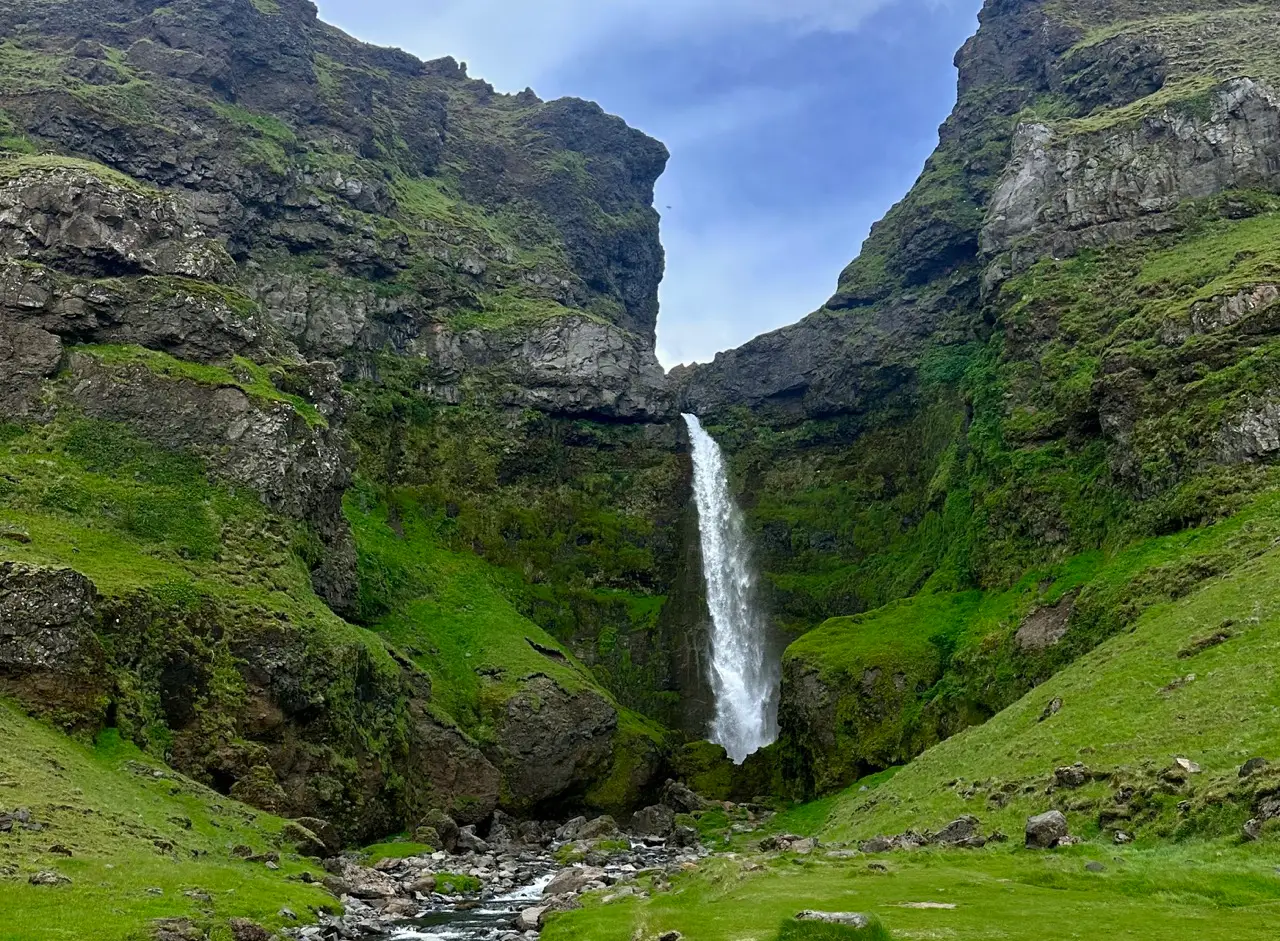 View of waterfall on green mountains