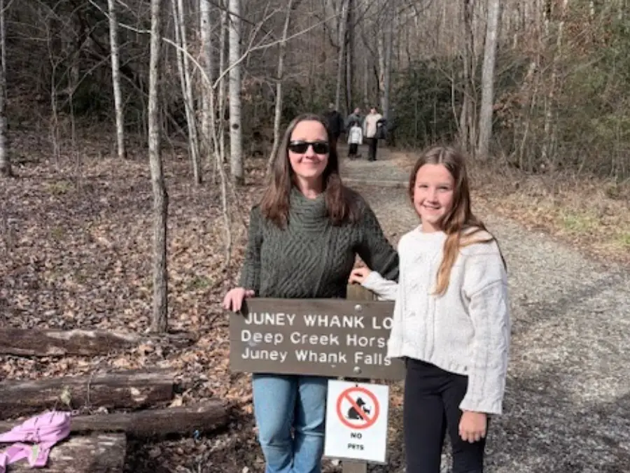 The writer and her daughter standing in front of a trail in Bryson City.