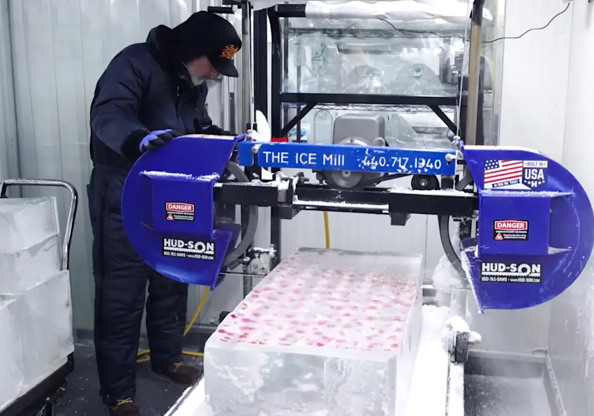 Man cutting a giant block of ice.