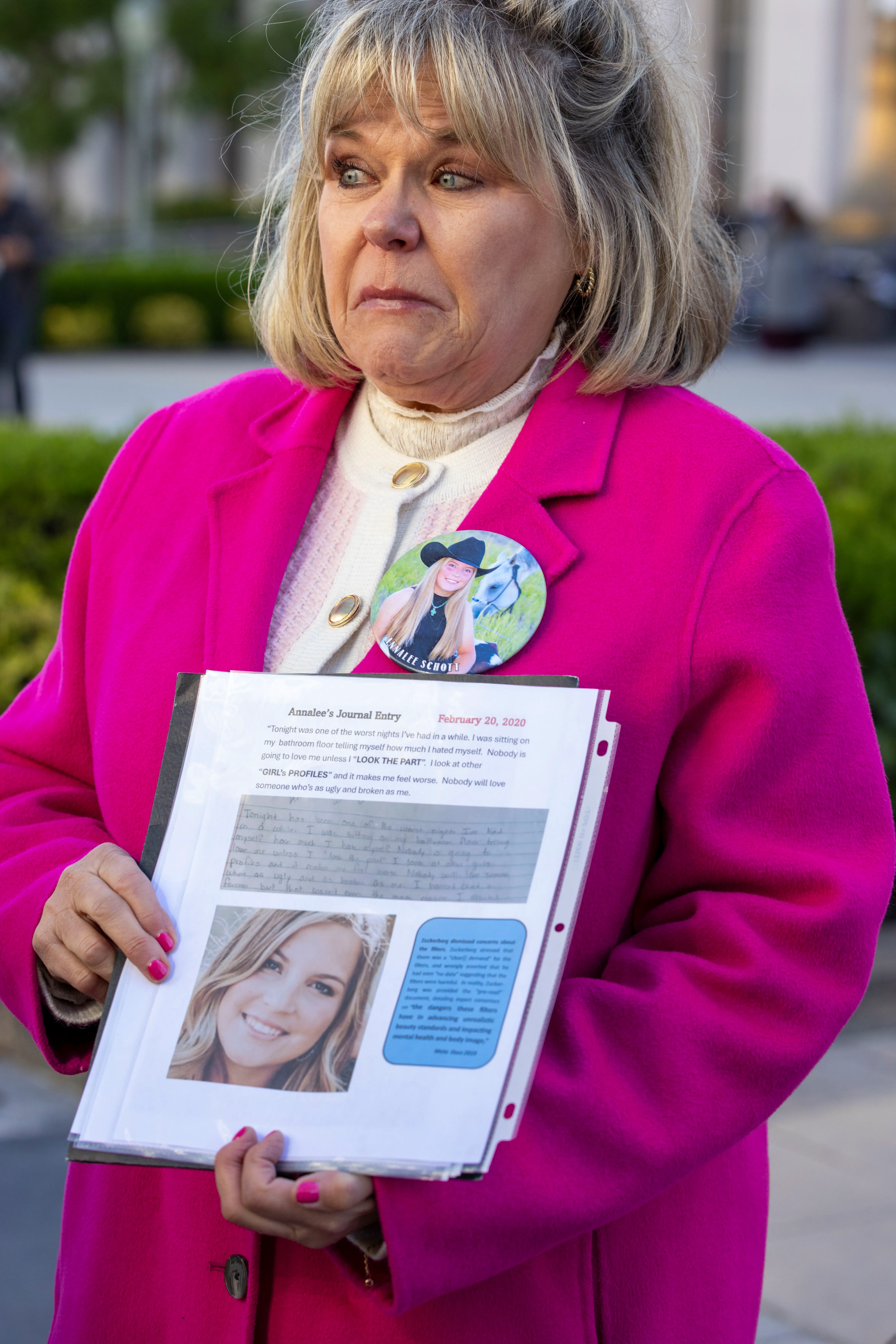 LOS ANGELES, CALIFORNIA - FEBRUARY 18: Lori Schott , holds a picture of her daughter Annalee who died by suicide after consuming social media content on depression, anxiety and suicide, stands outside the Los Angeles Superior Court at United States Court House on February 18, 2026 in Los Angeles, California. A 20-year-old California woman sued Meta and YouTube accusing them of building addictive platforms causing harm to children. Schmitt is not part of this case but has a separate social media case and came to advocate and raise awareness. (Photo by Jill Connelly/Getty Images)