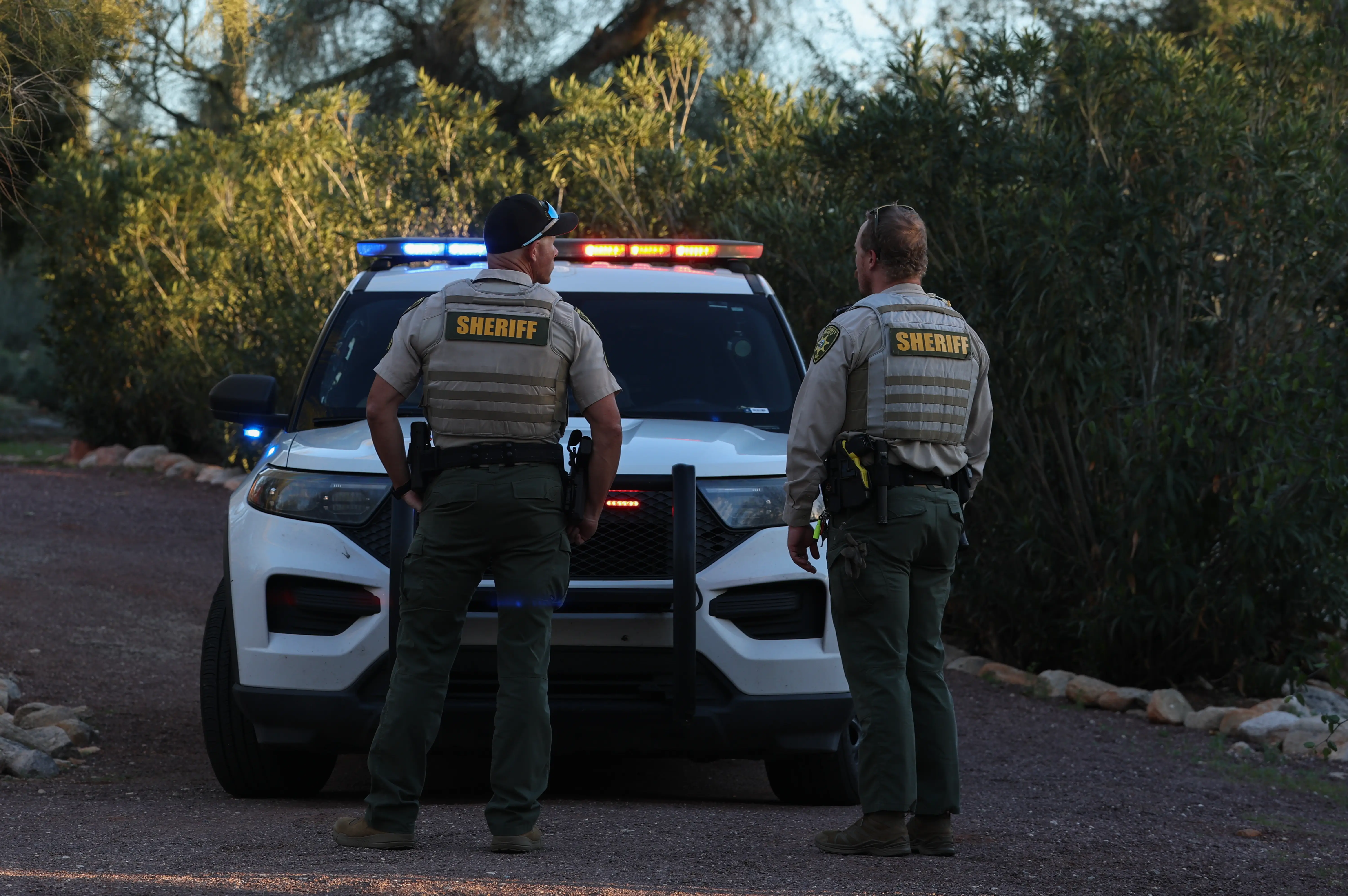 Pima County deputy sheriffs stand in the driveway of the residence of Nancy Guthrie on February 18, 2026,